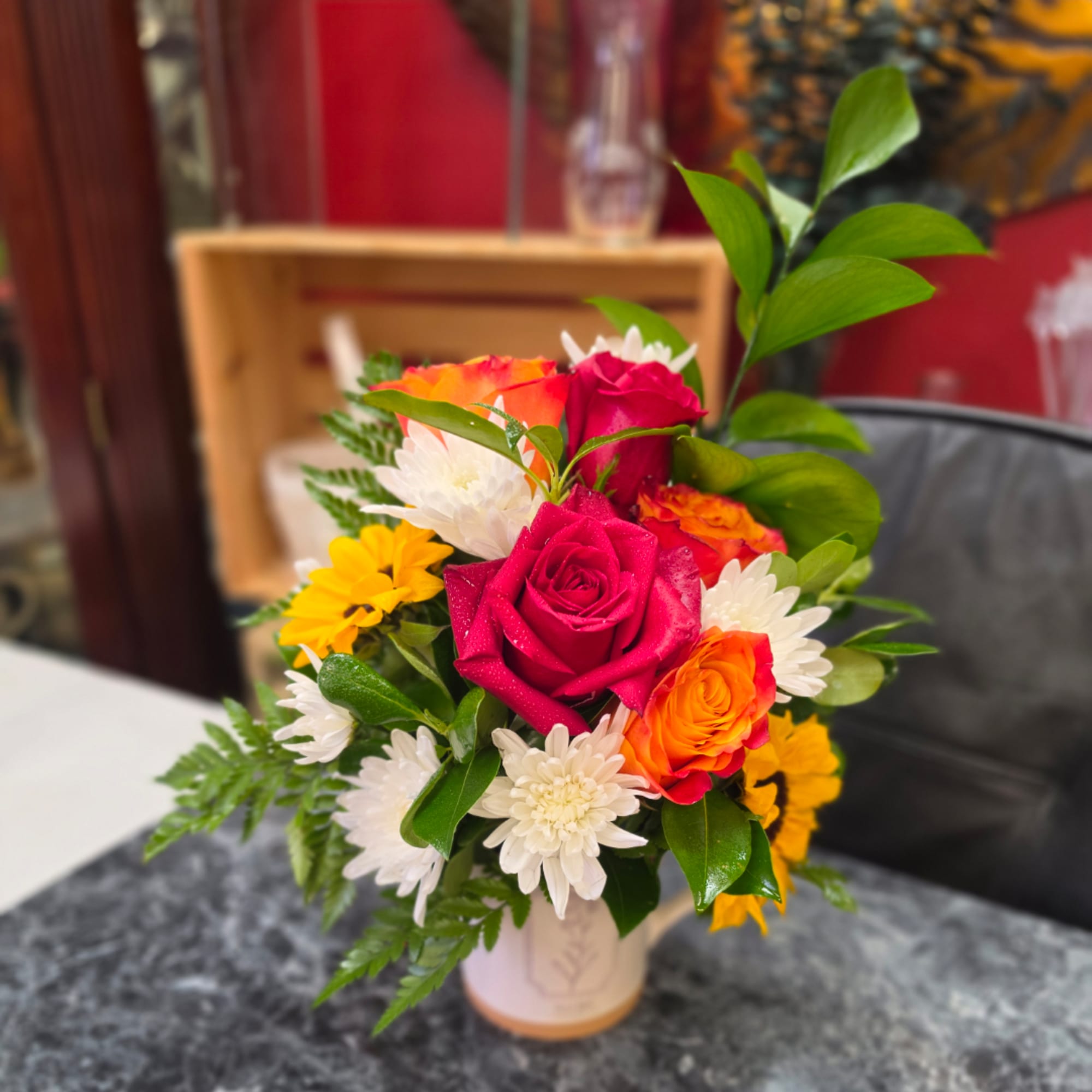 Mixed bouquet of pink and orange roses with white daisies in a vase
