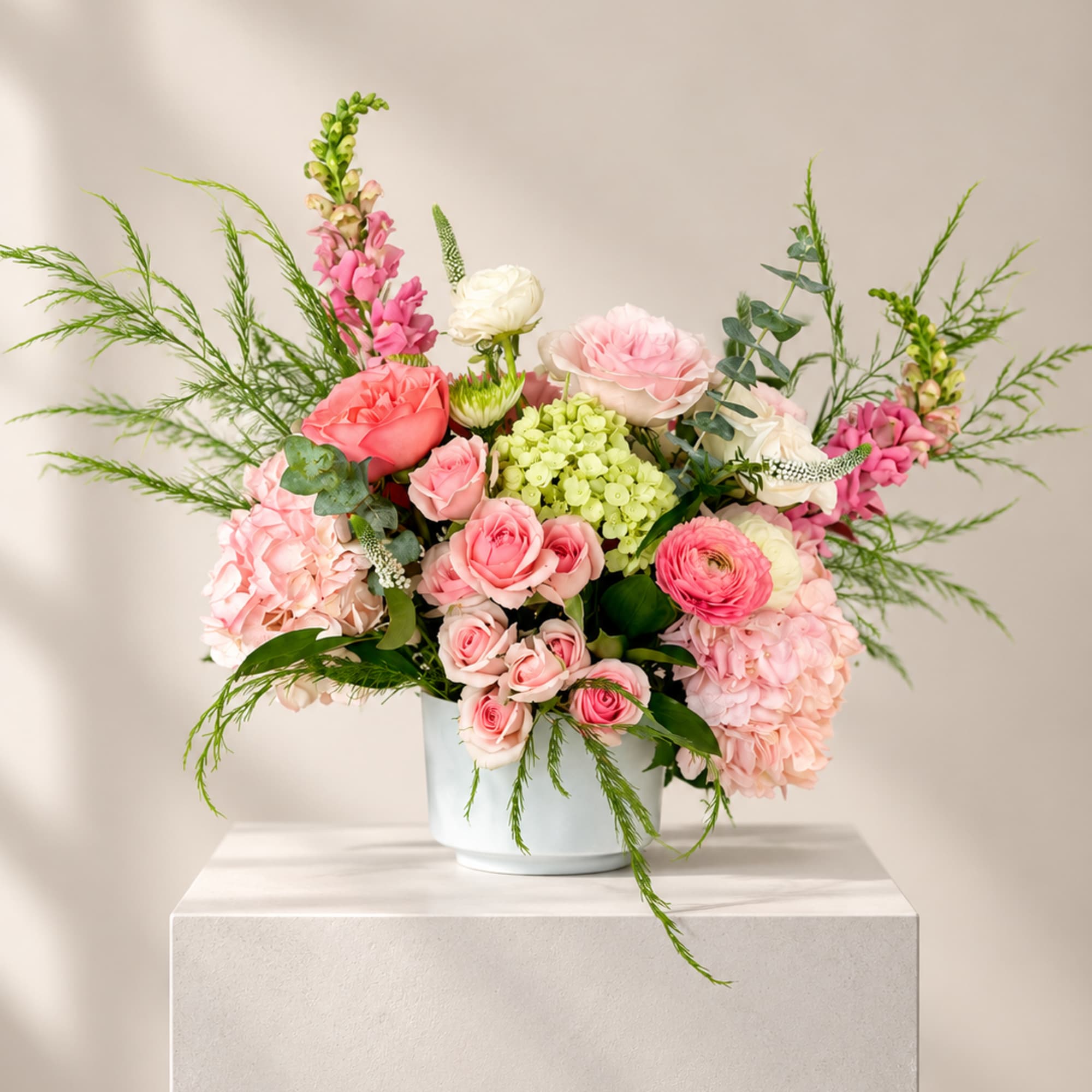 Pink and white floral arrangement in a pale blue vase