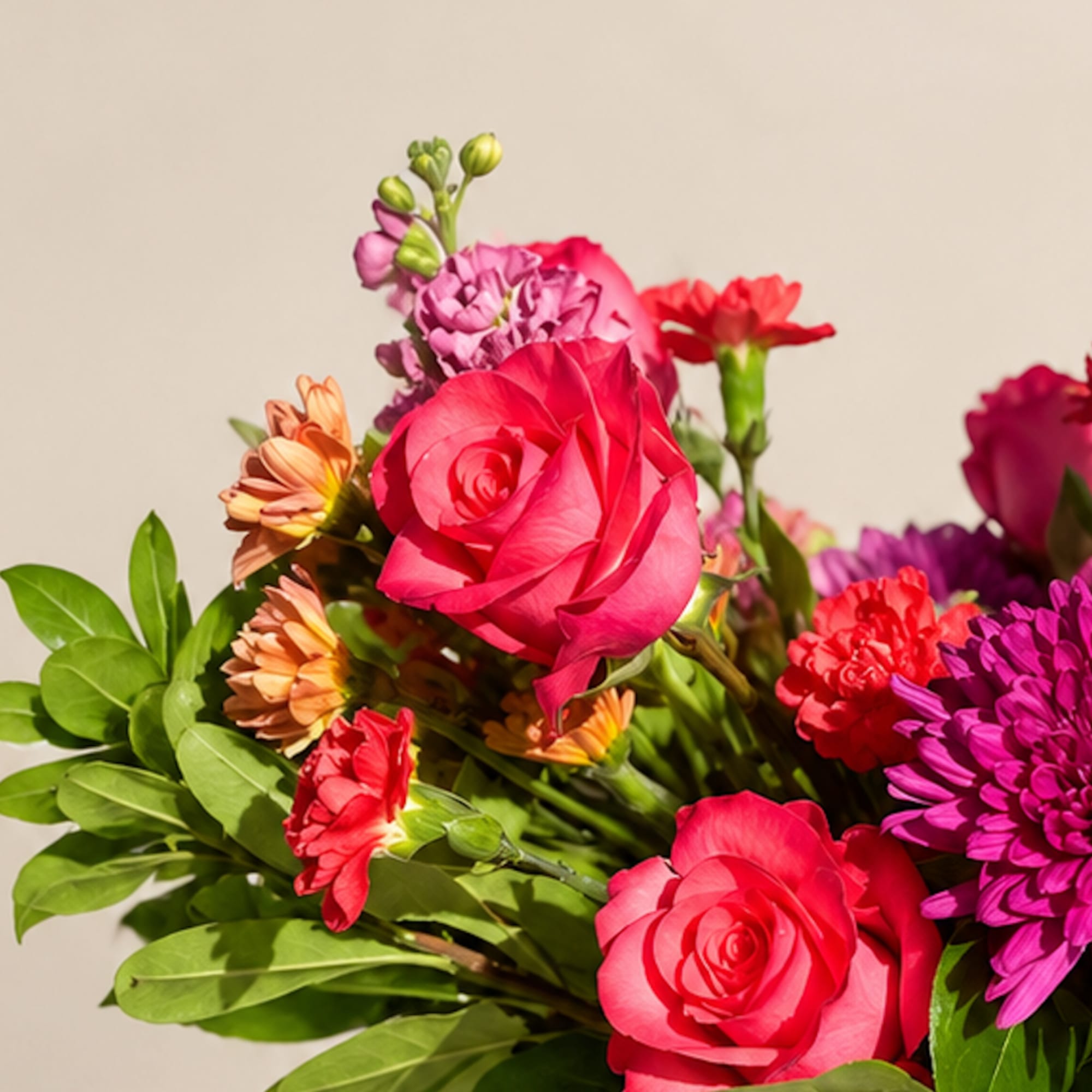 Bouquet of pink roses and colorful mixed flowers against a plain background