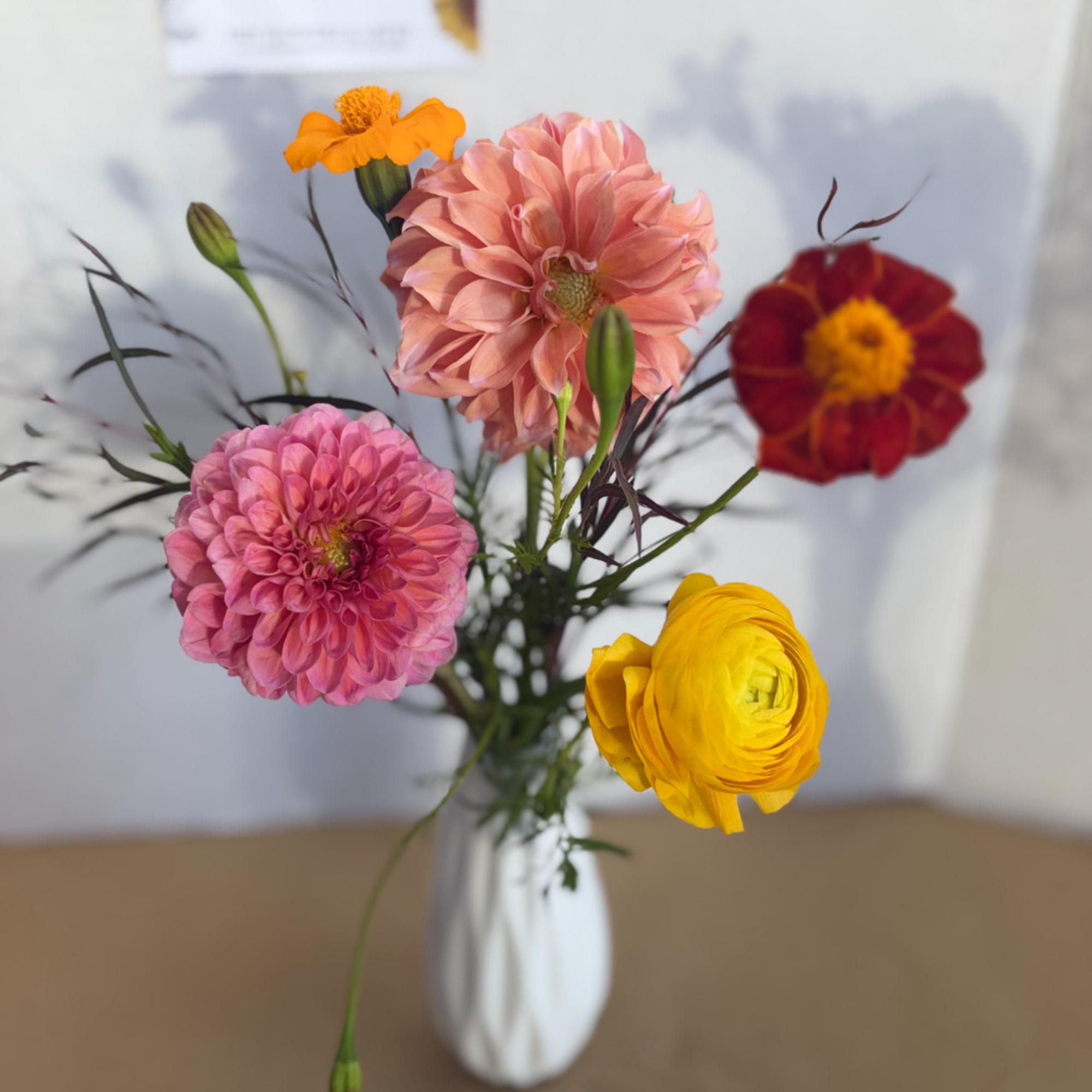 Mixed bouquet of colorful flowers in a white vase