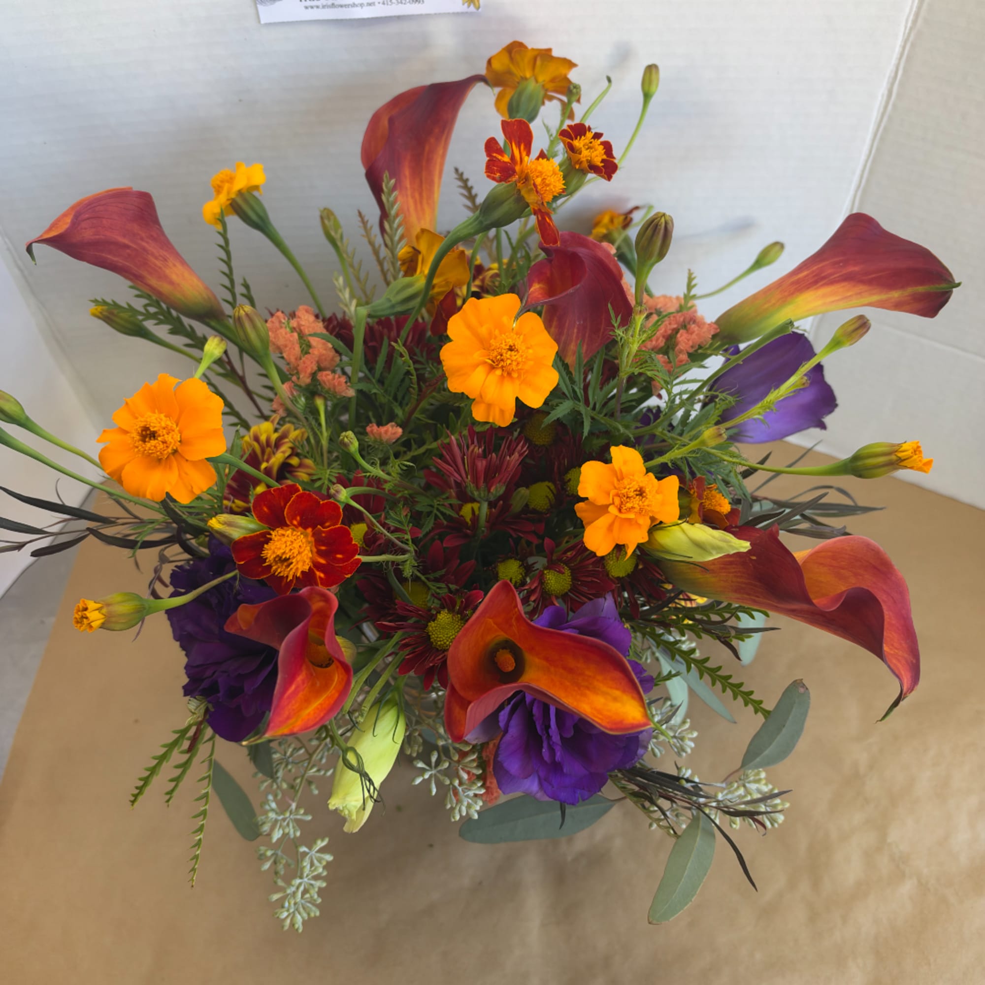 Colorful bouquet with orange and burgundy calla lilies and small mixed blooms