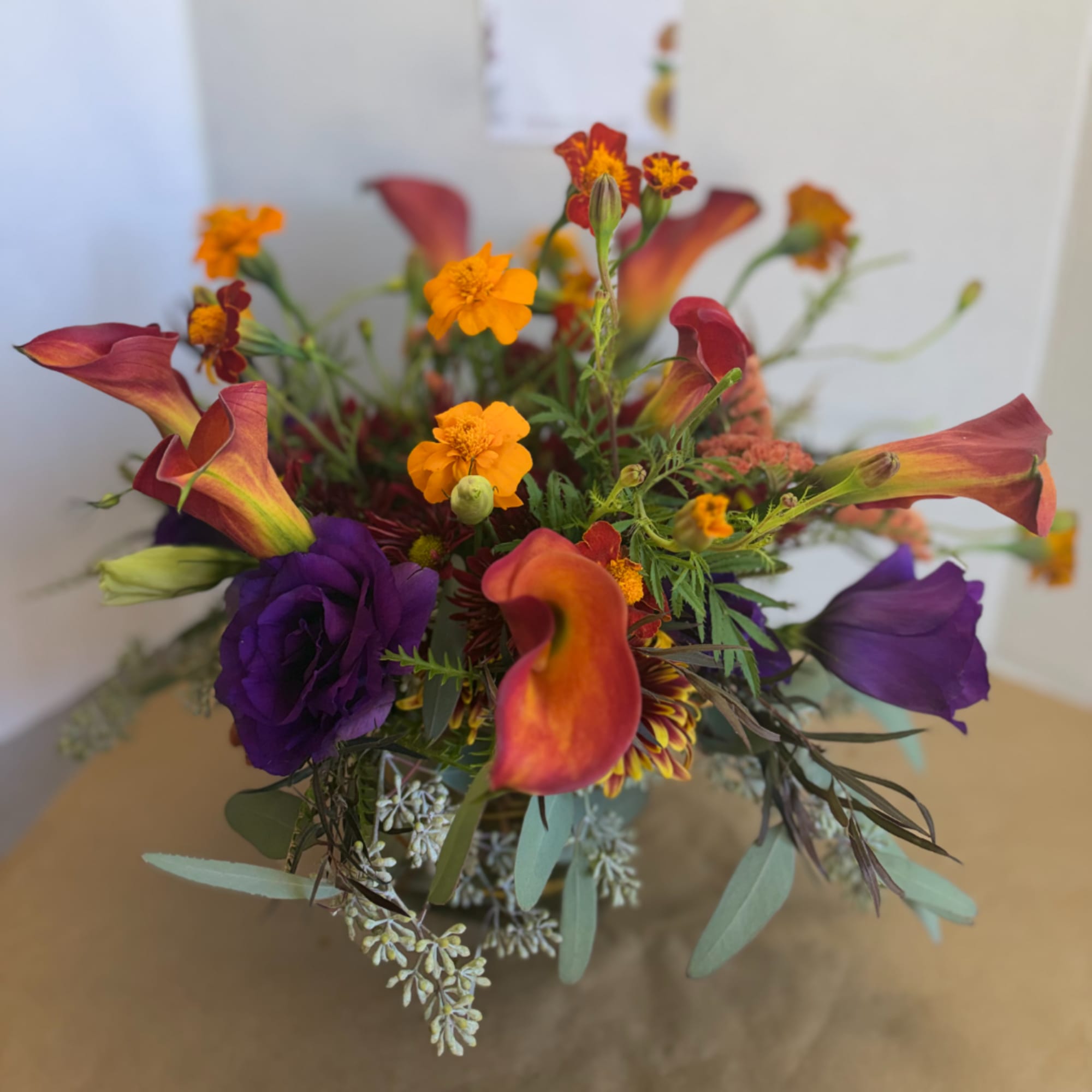 Bouquet with orange calla lilies and purple lisianthus in a vase