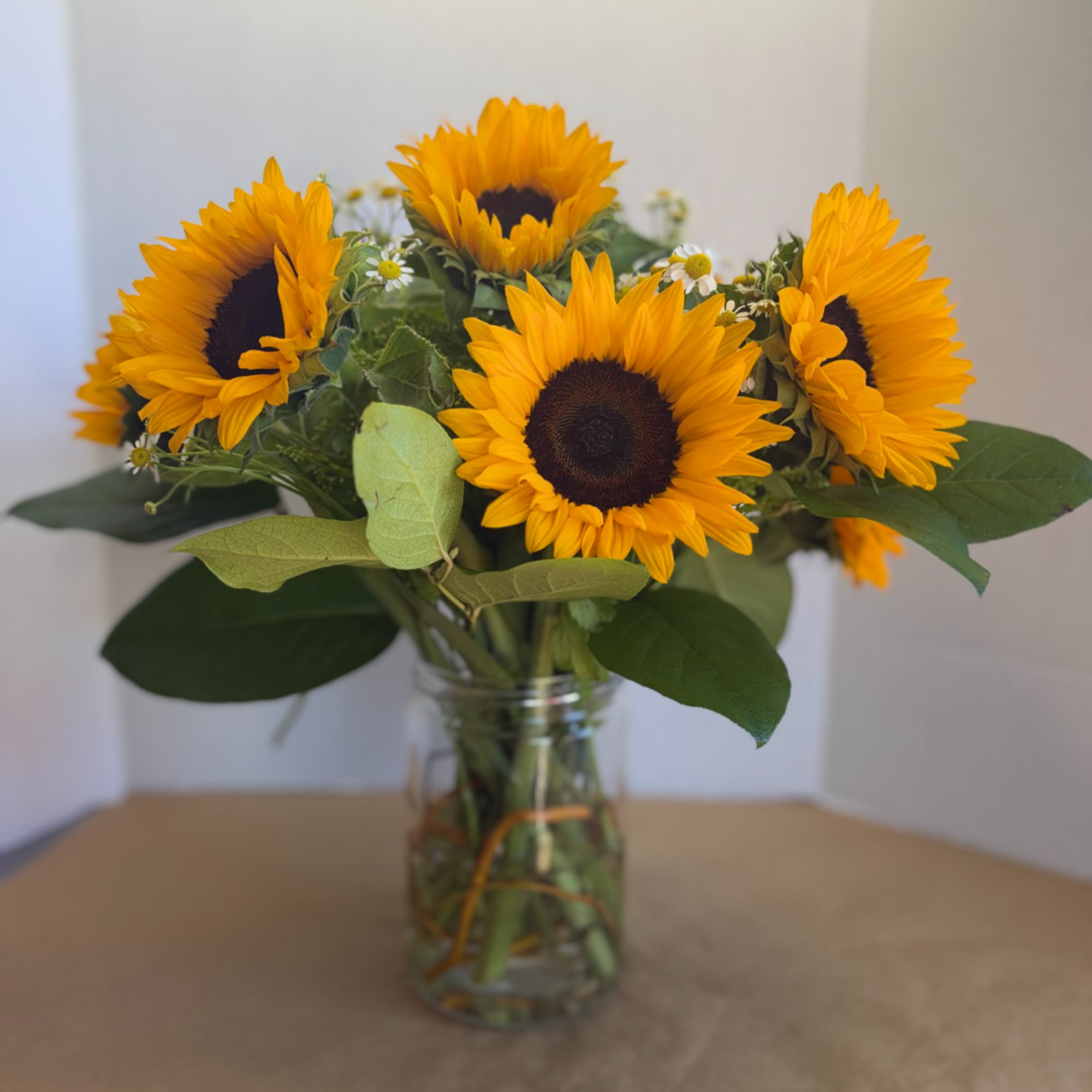Sunflower bouquet in a clear glass jar vase