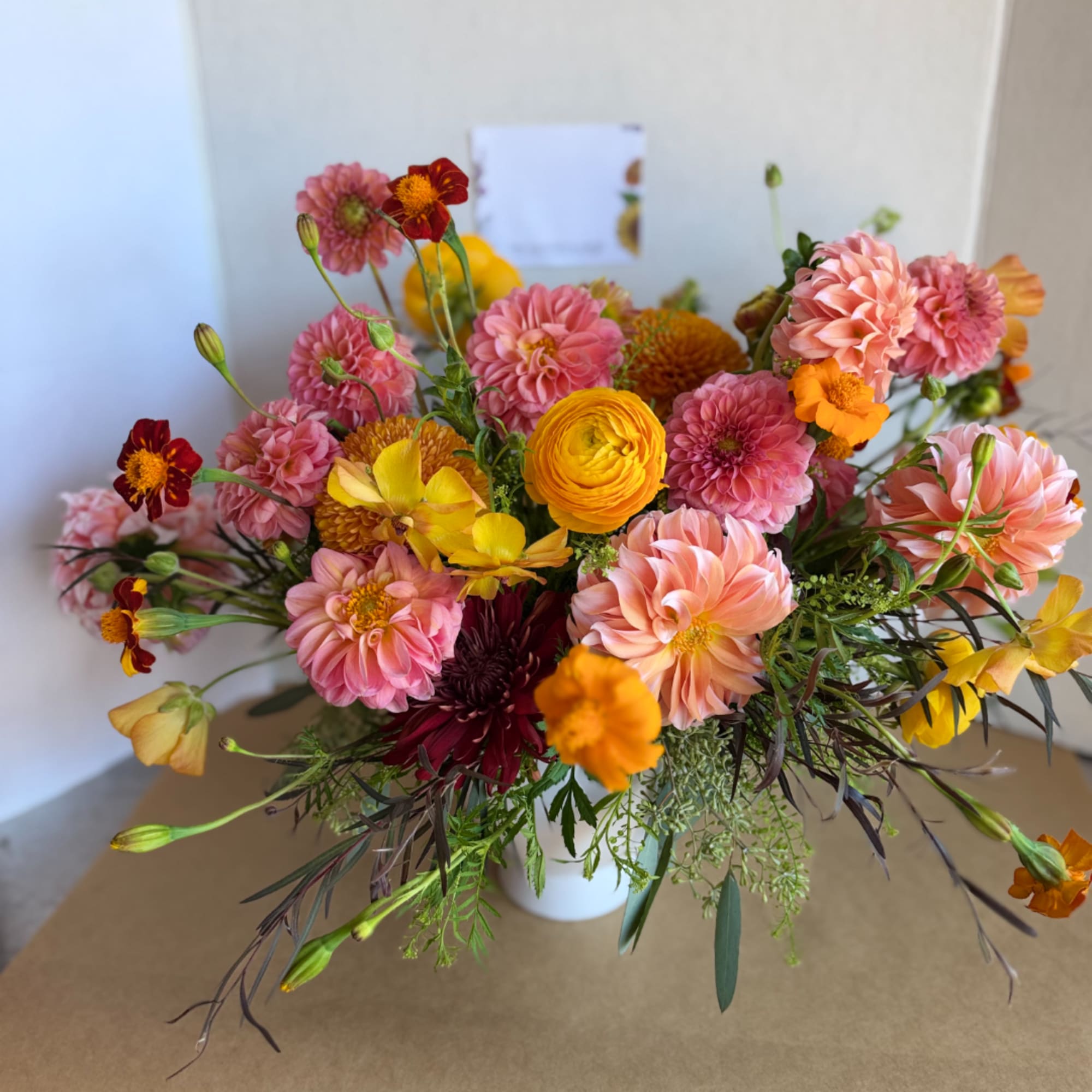 Pink and orange mixed bouquet in a white vase