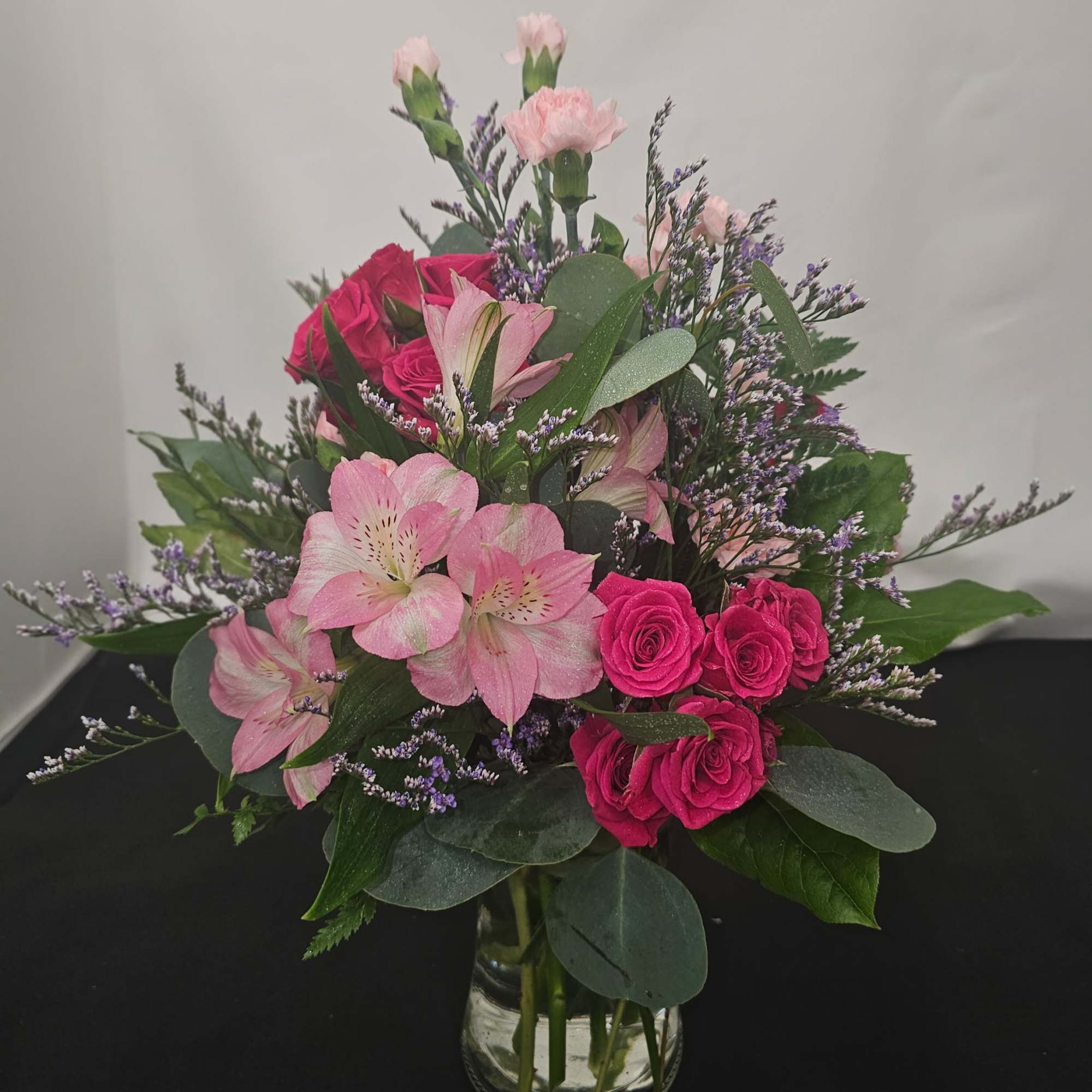 Pink roses and alstroemeria in a clear glass vase