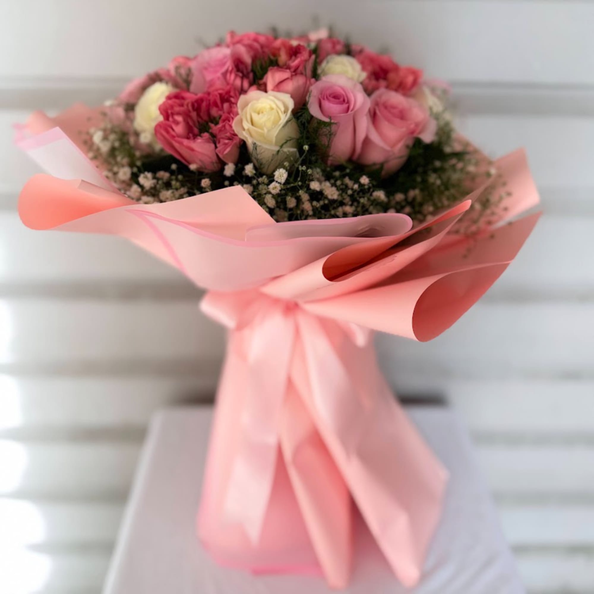Pink and cream rose bouquet wrapped in pale pink paper