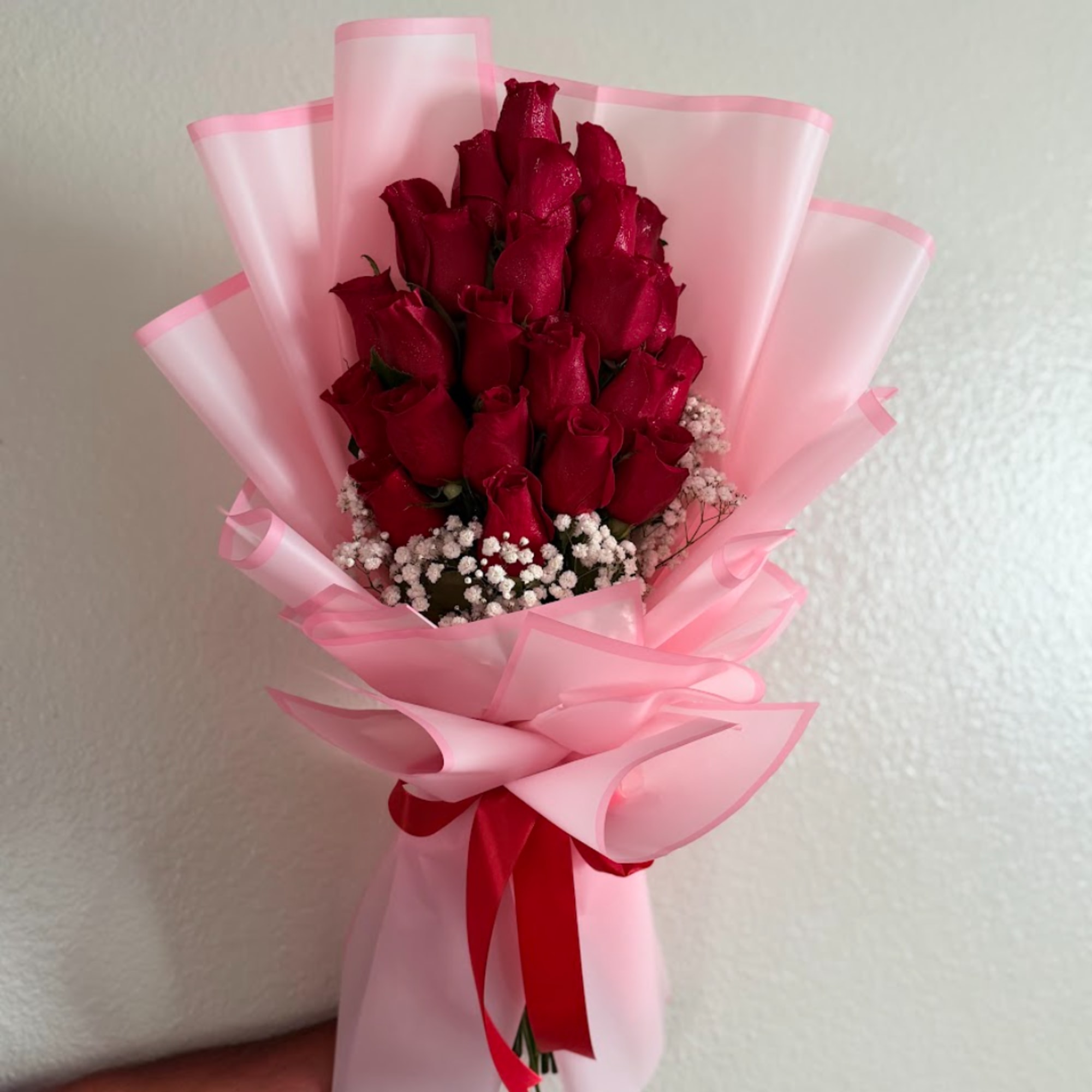 Bouquet of red roses wrapped in pink paper with a red ribbon, photo 2 of 2