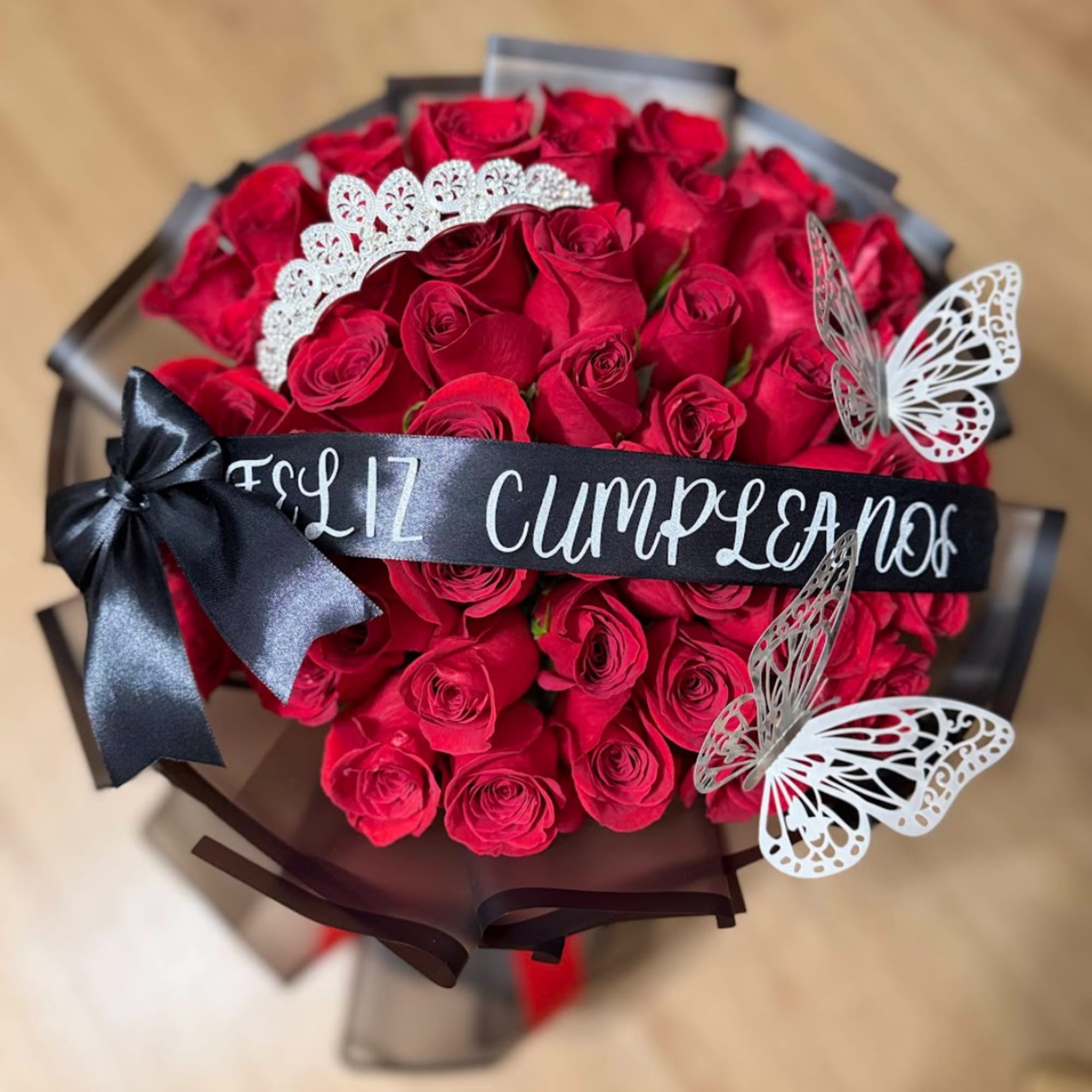 Bouquet of red roses with a black ribbon and butterfly decorations, photo 2 of 3
