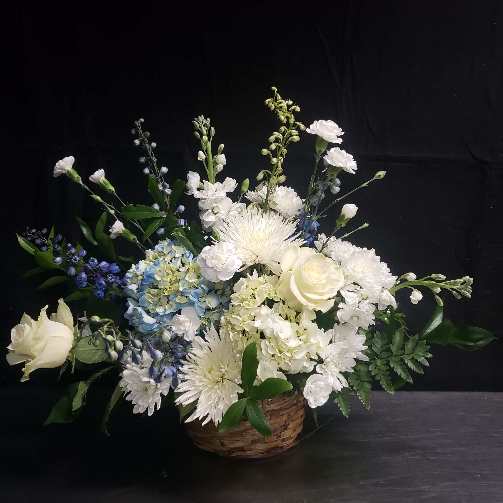 A serene mix of white roses and pale blue hydrangeas creates a