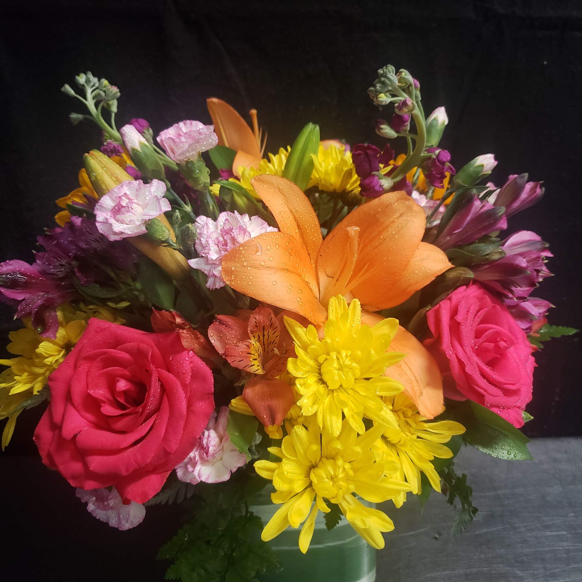 A bold orange lily crowns this mixed bouquet, surrounded by bright pink