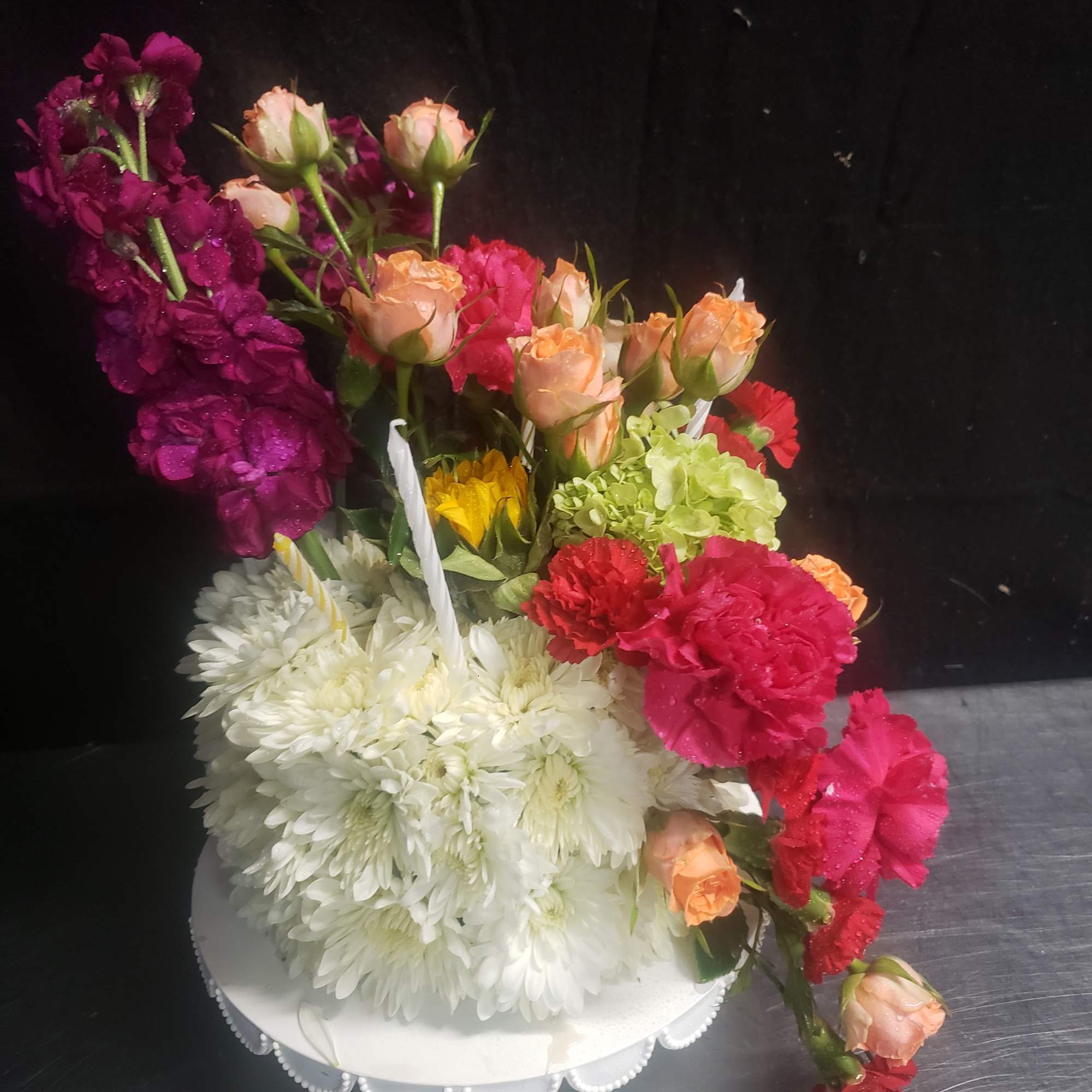 A dense mound of white chrysanthemums forms the clean, sculpted base of