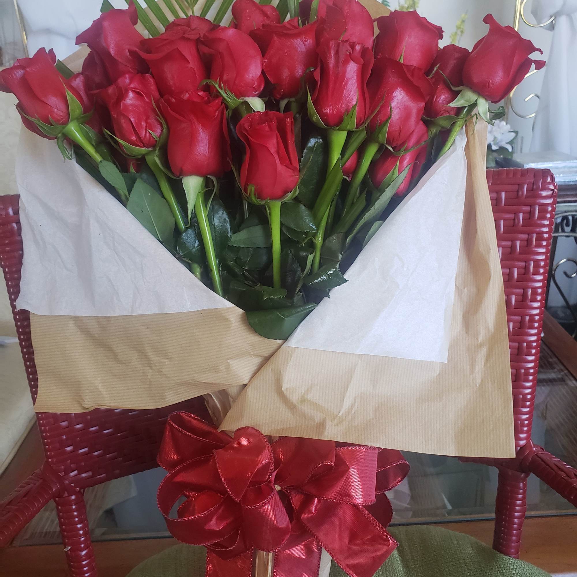 A dense cluster of velvety red roses gathered into a hand-tied bouquet