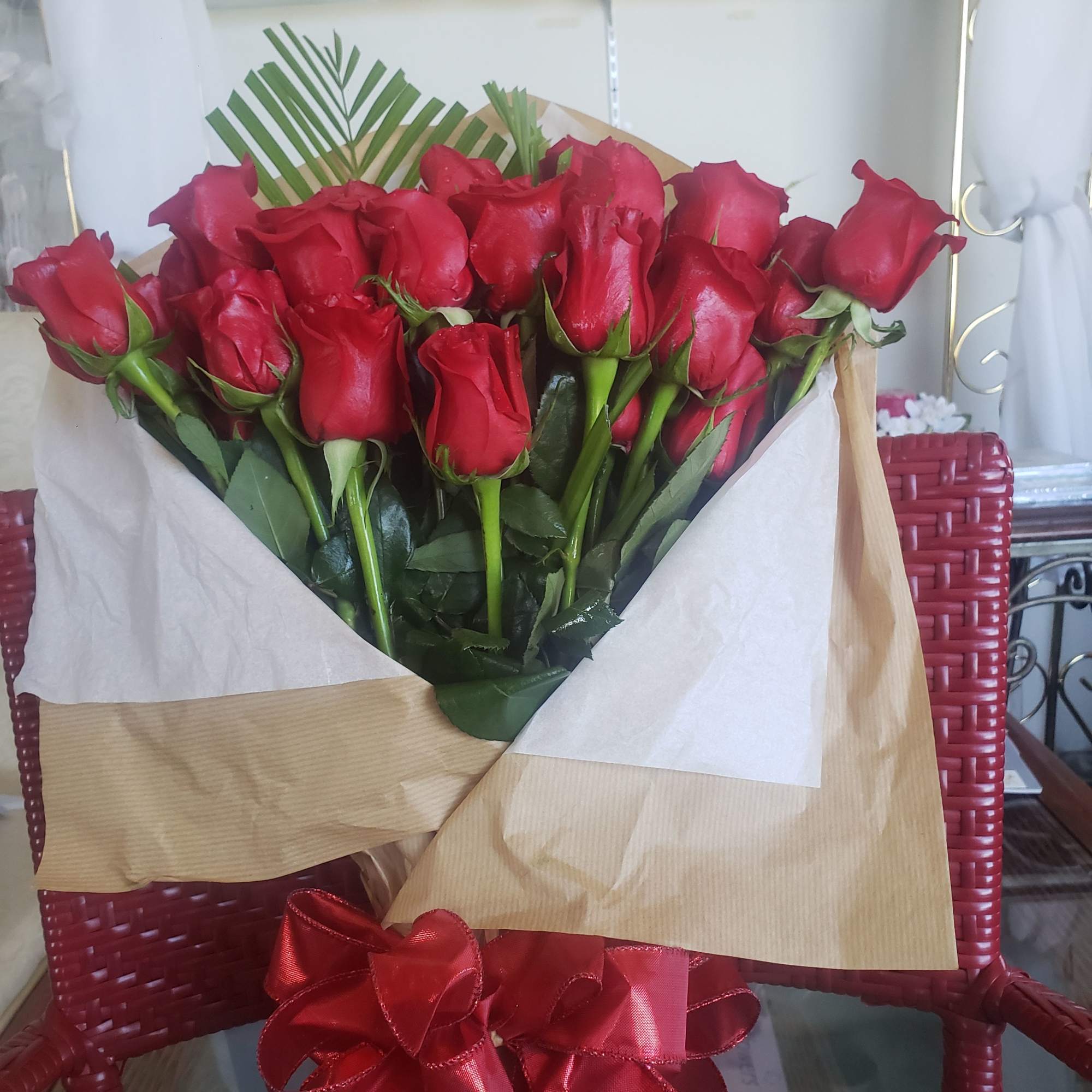 A dense cluster of velvety red roses gathered into a hand-tied bouquet