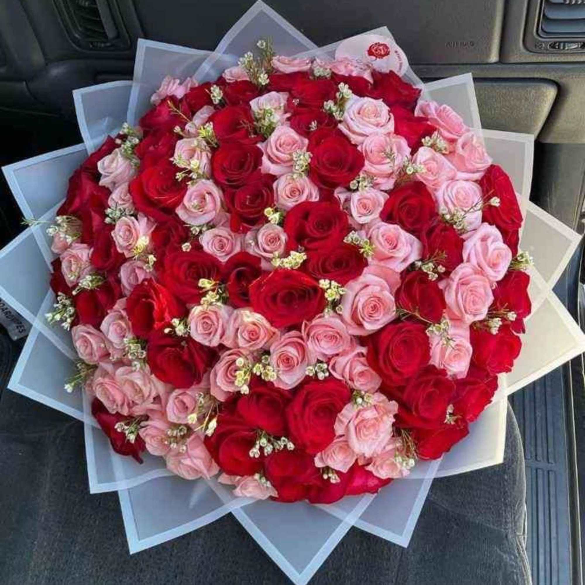 A lush, hand-tied floral bouquet built around classic roses and lilies-BUCHONES is