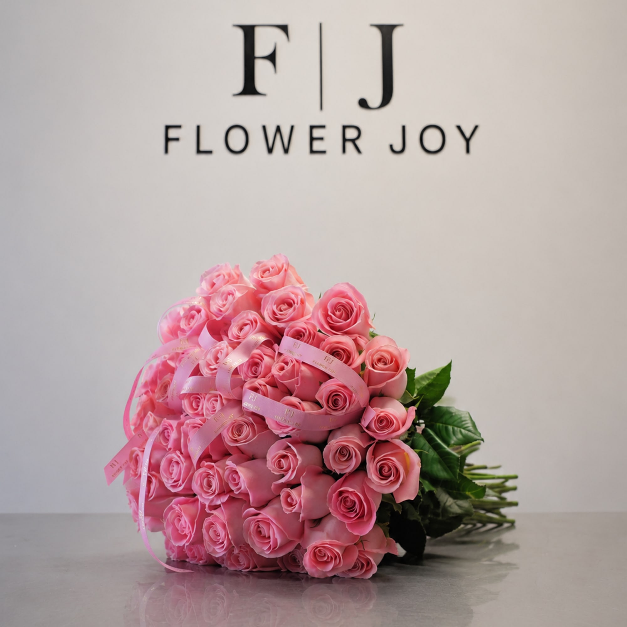 A beautiful bouquet of vibrant pink roses, finished with elegant ribbon details.