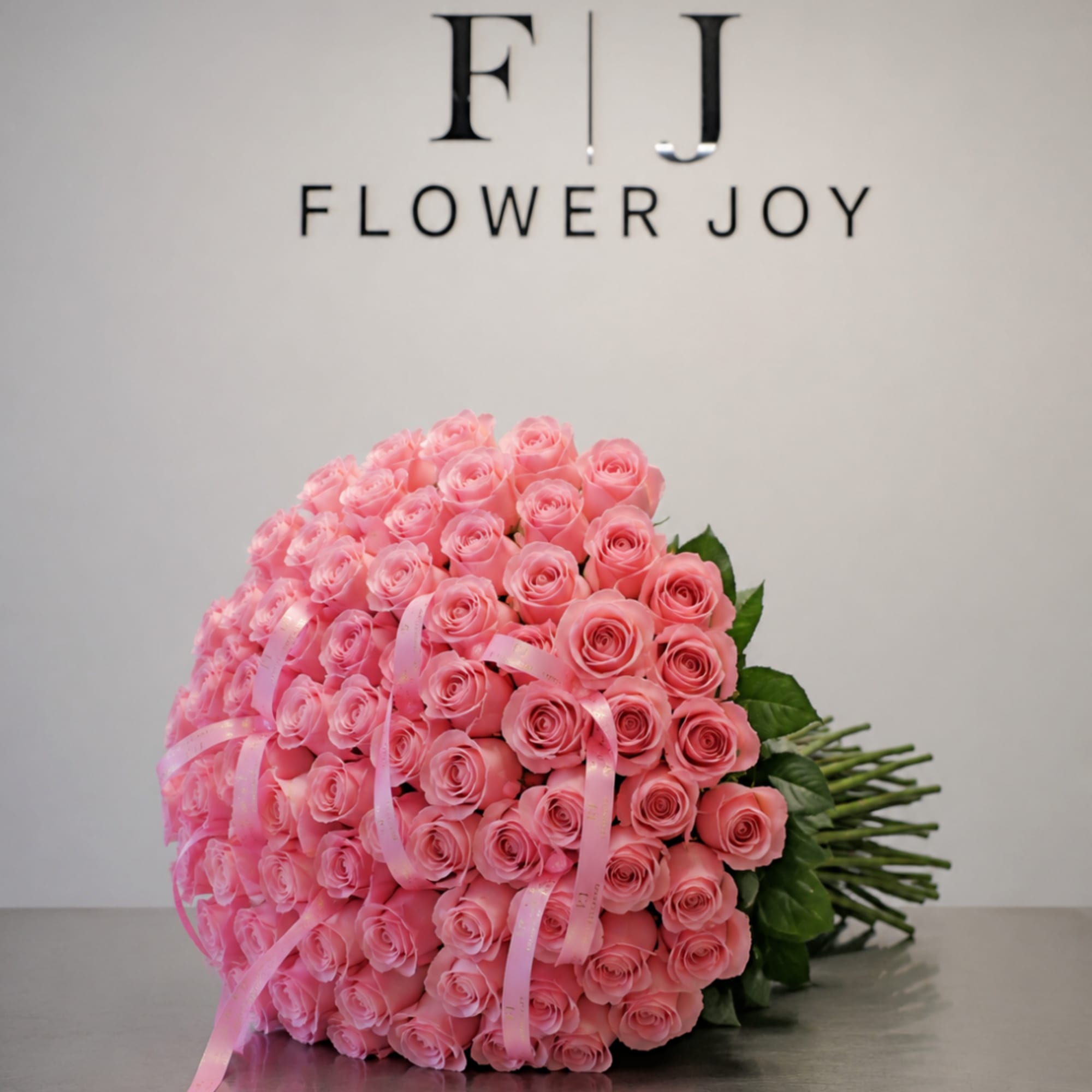 Large bouquet of pink roses tied with pink ribbon