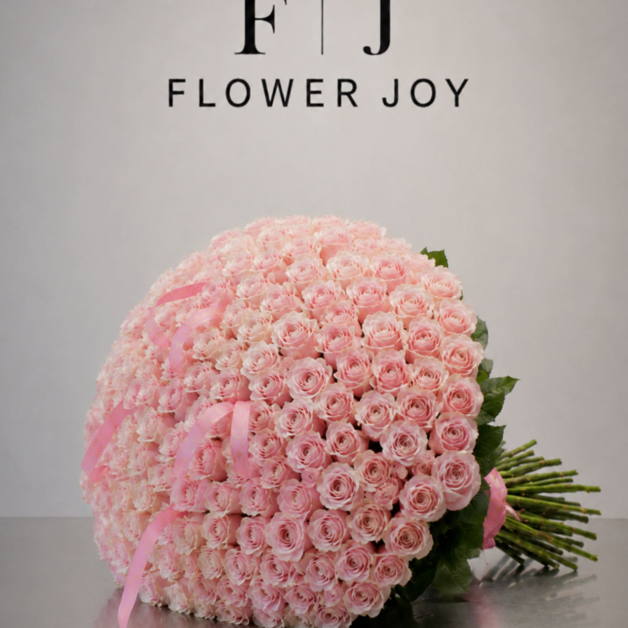 Large bouquet of pale pink roses tied with pink ribbon
