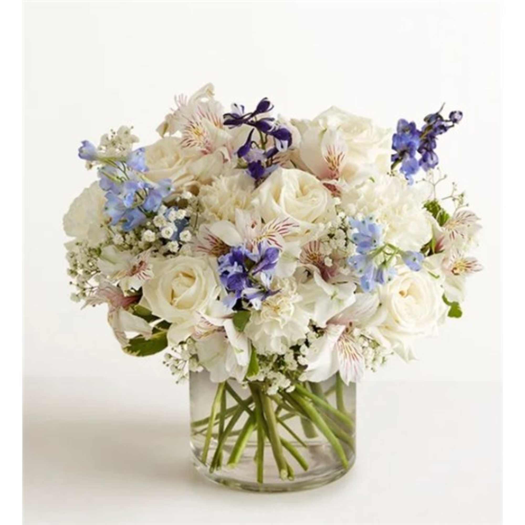 White and blue mixed bouquet in a clear glass vase