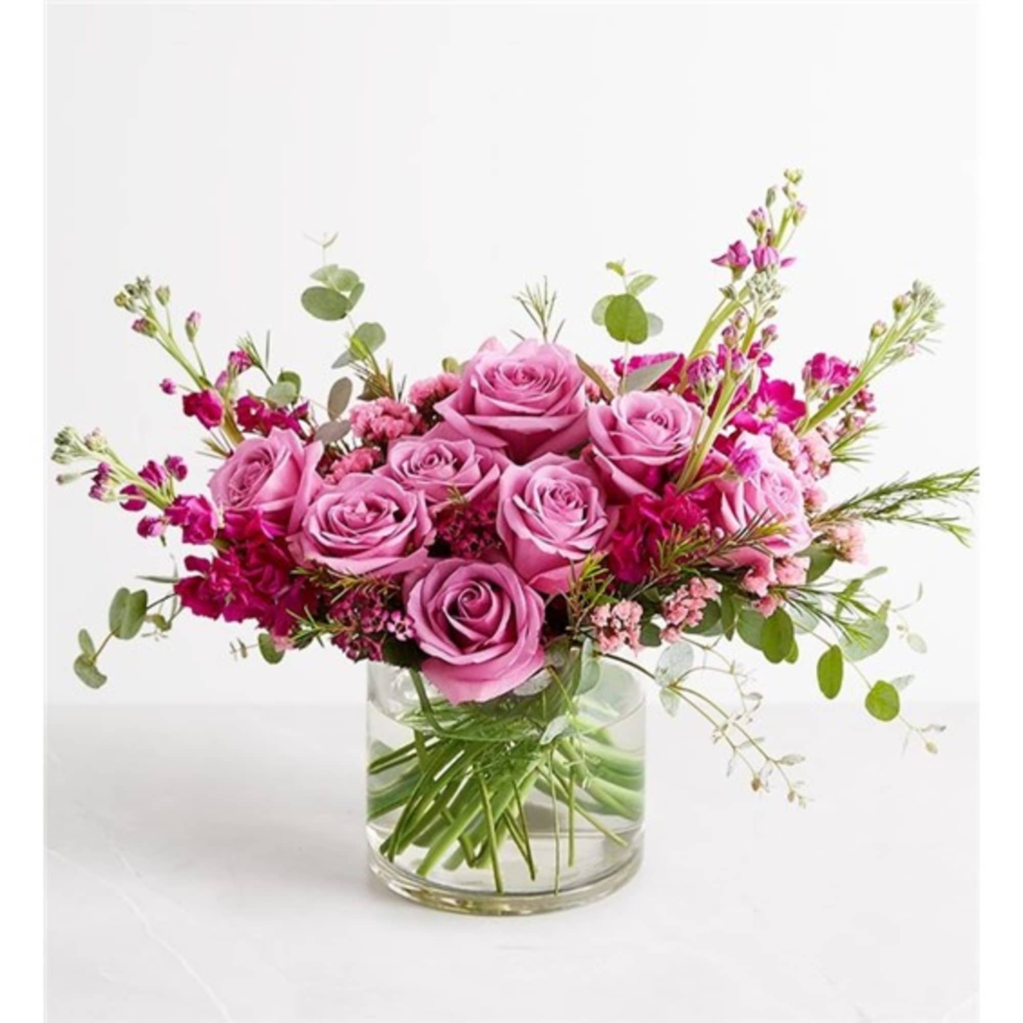 Pink roses arranged in a clear glass vase with airy filler flowers