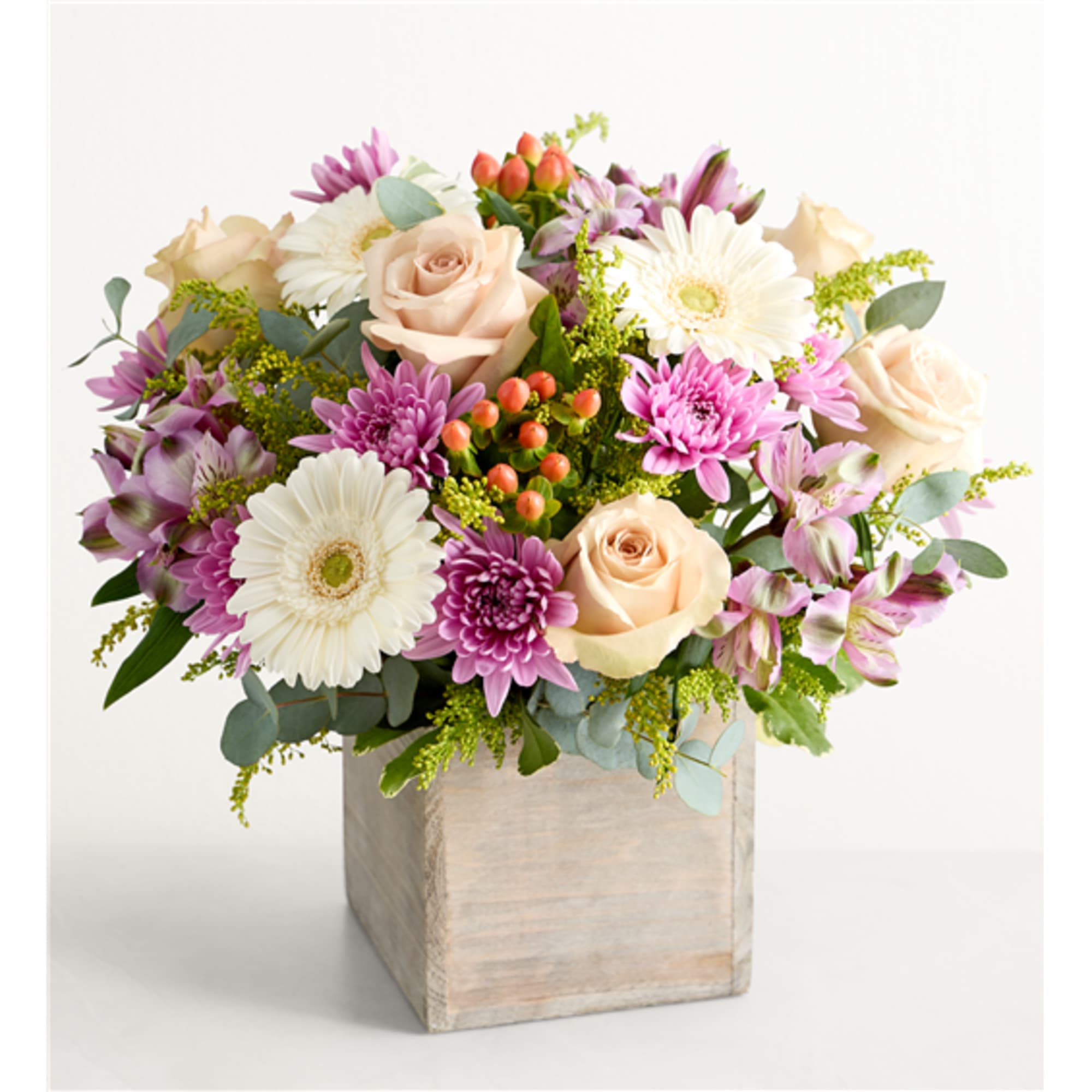 Bouquet of pink and white flowers in a wooden cube vase