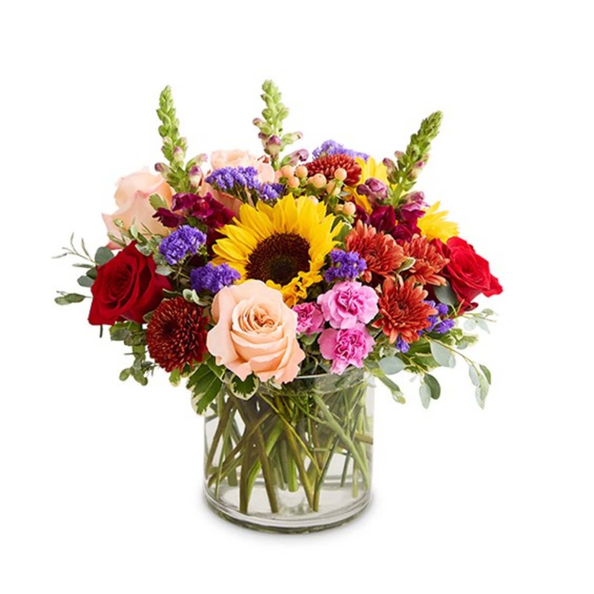 Mixed bouquet in a clear glass vase with sunflowers, roses, and colorful blooms