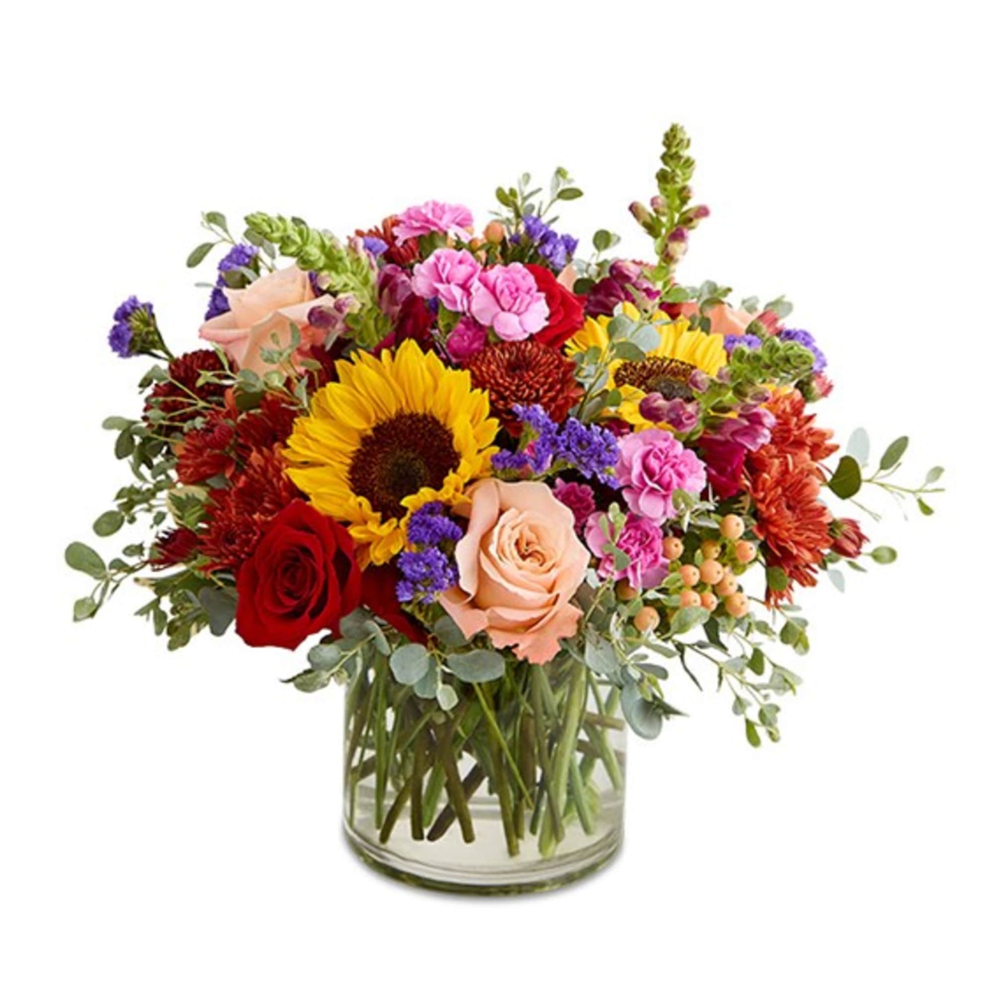Mixed bouquet of sunflowers, roses, and carnations in a glass vase