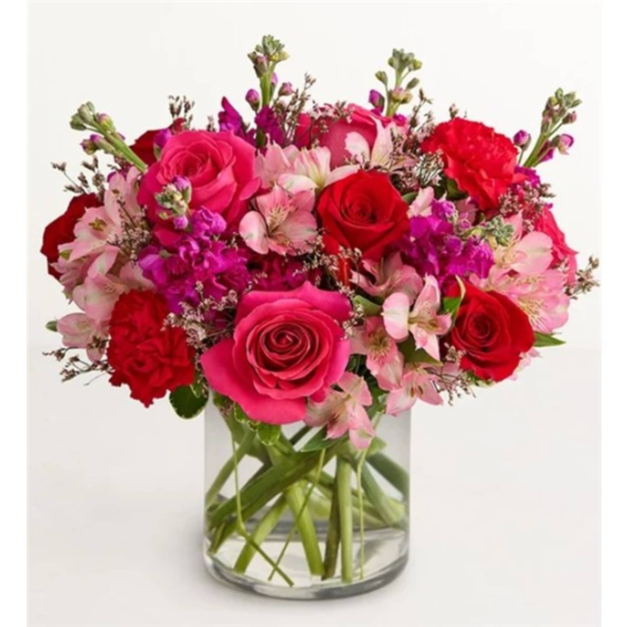 Bouquet of pink and red roses with pink flowers in a clear glass vase