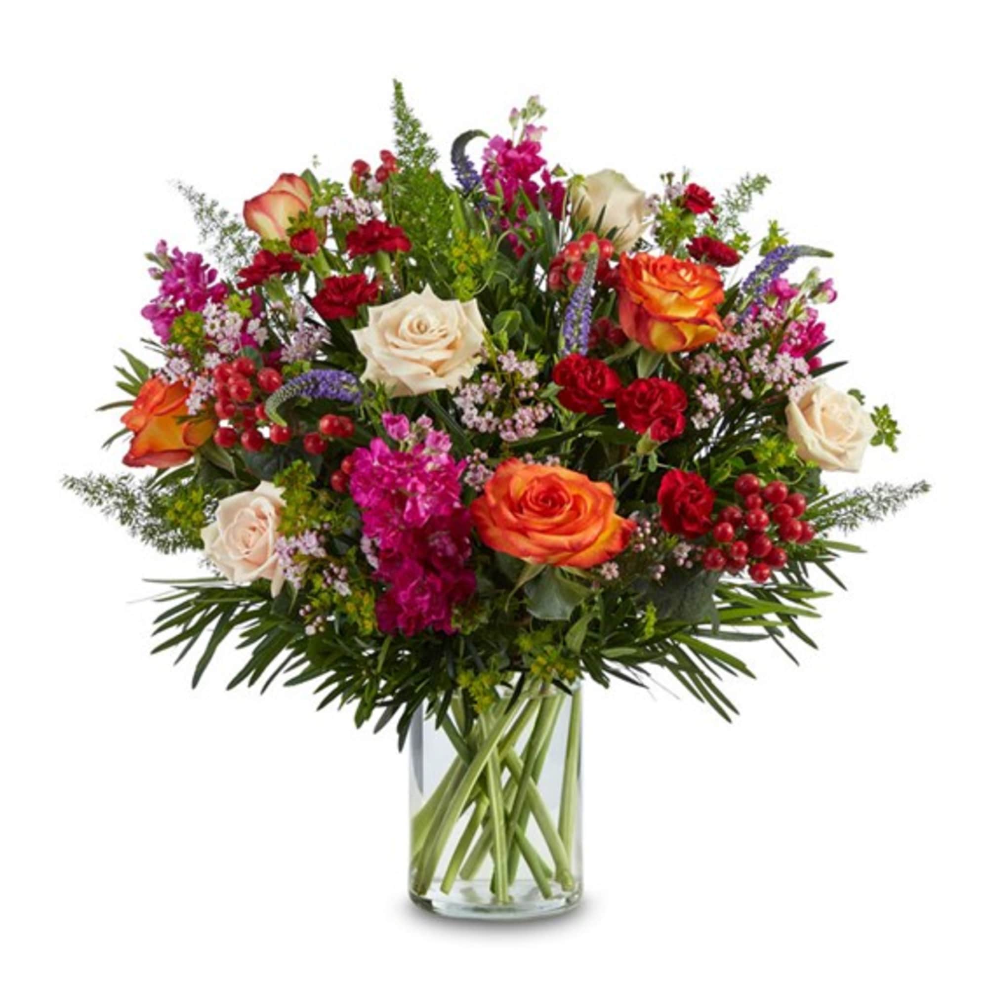 Mixed bouquet of roses and other flowers in a clear glass vase