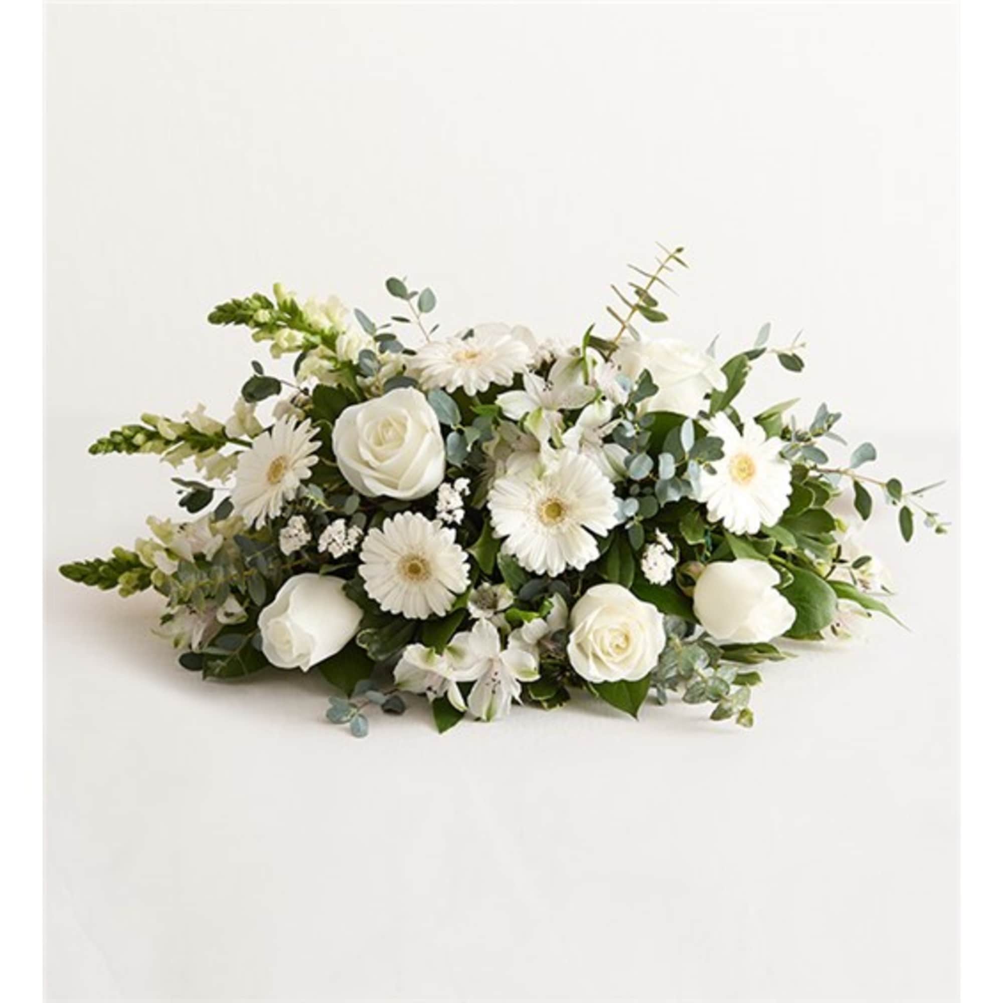 Low white floral arrangement with roses and daisy-like blooms
