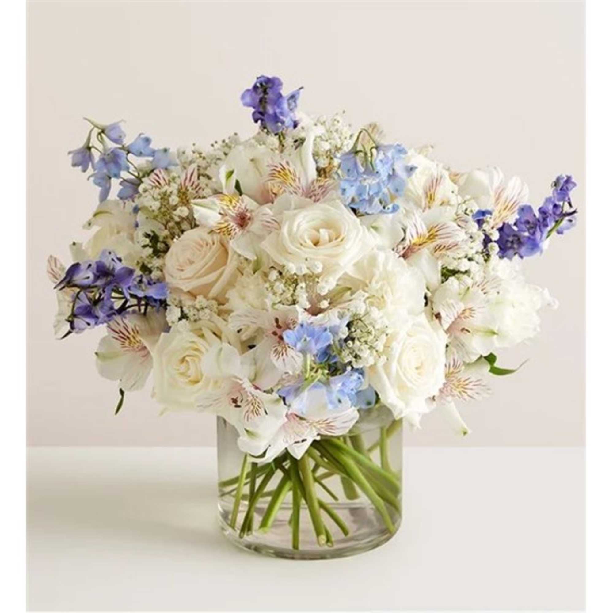 White and blue mixed bouquet in a clear glass vase