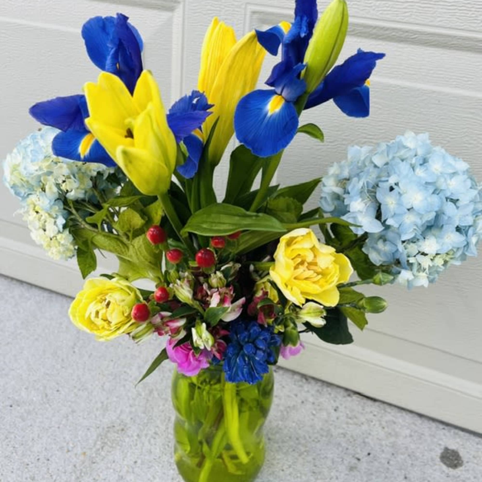 Bright, sunlit yellow tulip blooms ( seasonally made with rinanculus  or