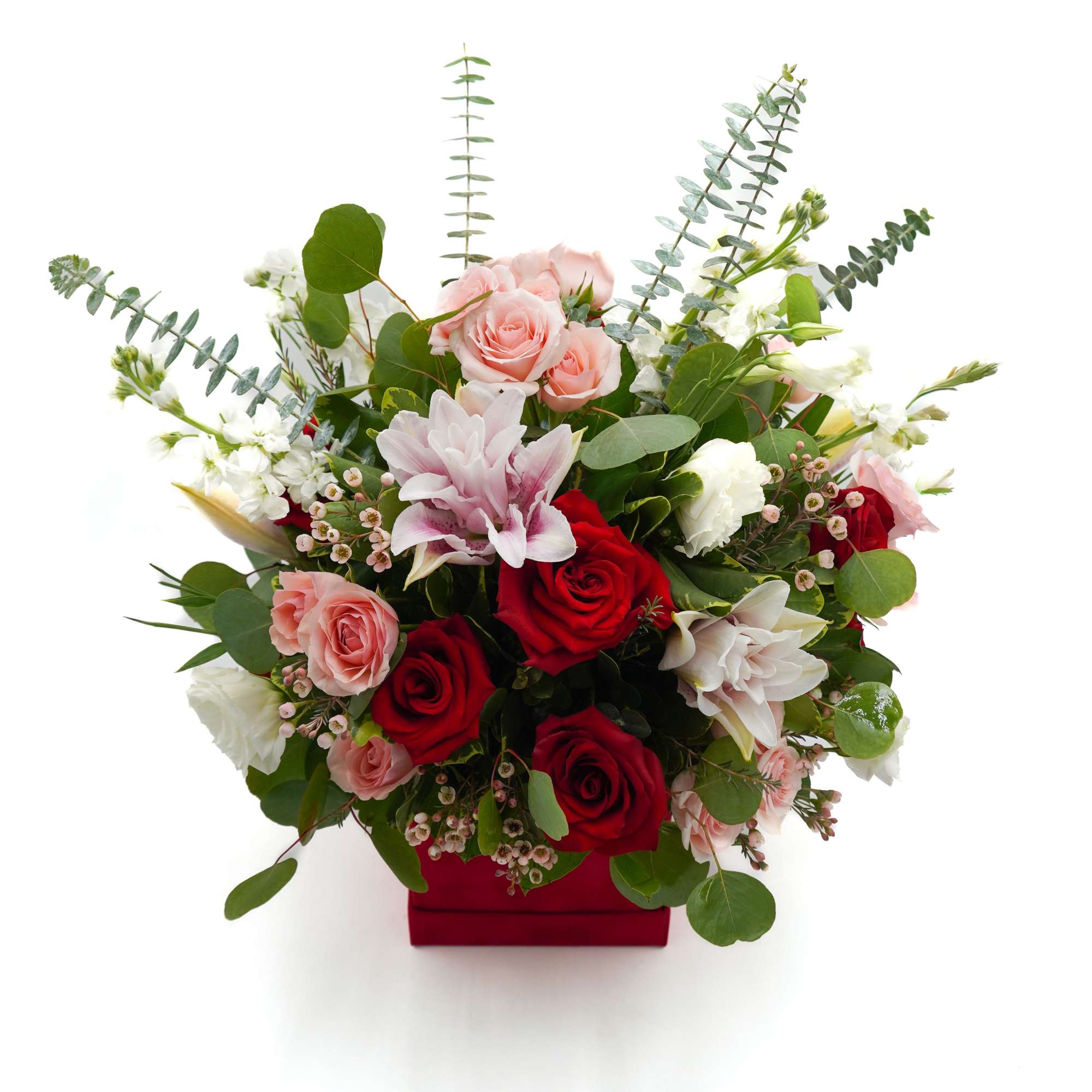 Bouquet of red and pink roses with white blooms in a red box