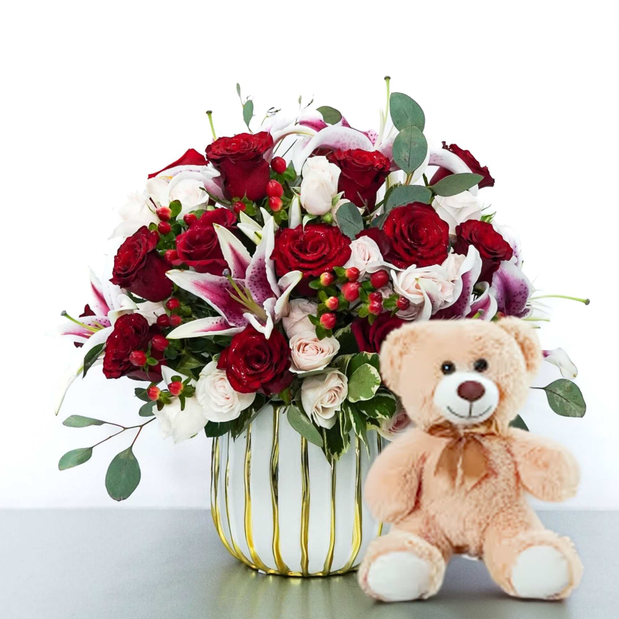 A mix of red, pink roses, and white lilies, accented with fresh