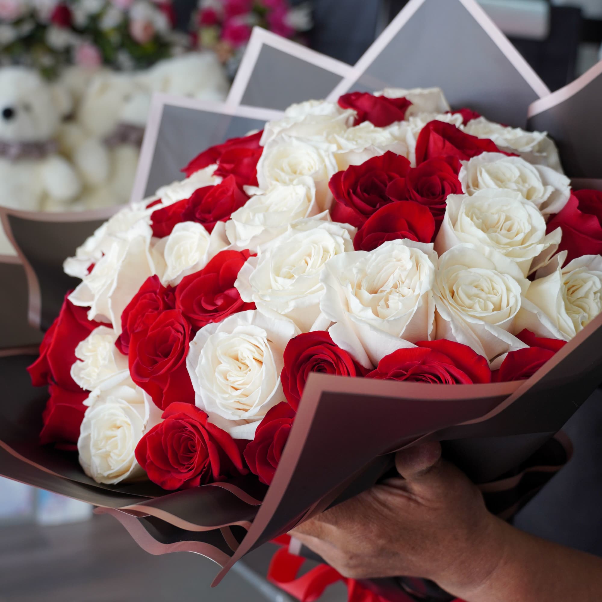 Bouquet of red and white roses wrapped in dark paper, photo 2 of 2