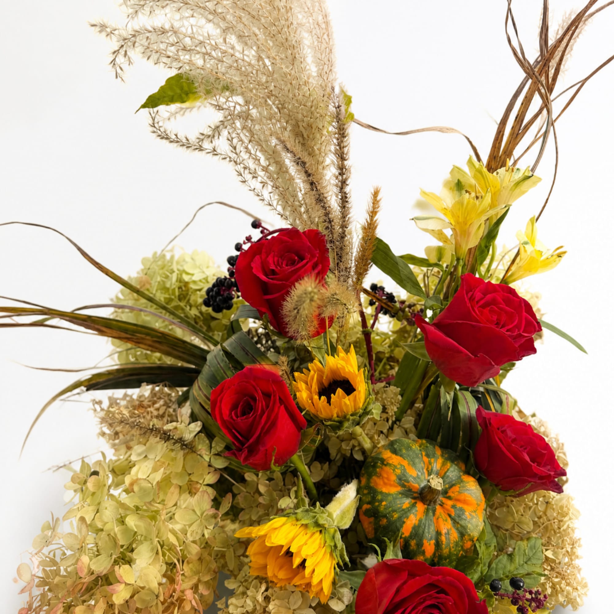 Bouquet of red roses and yellow flowers with a small pumpkin