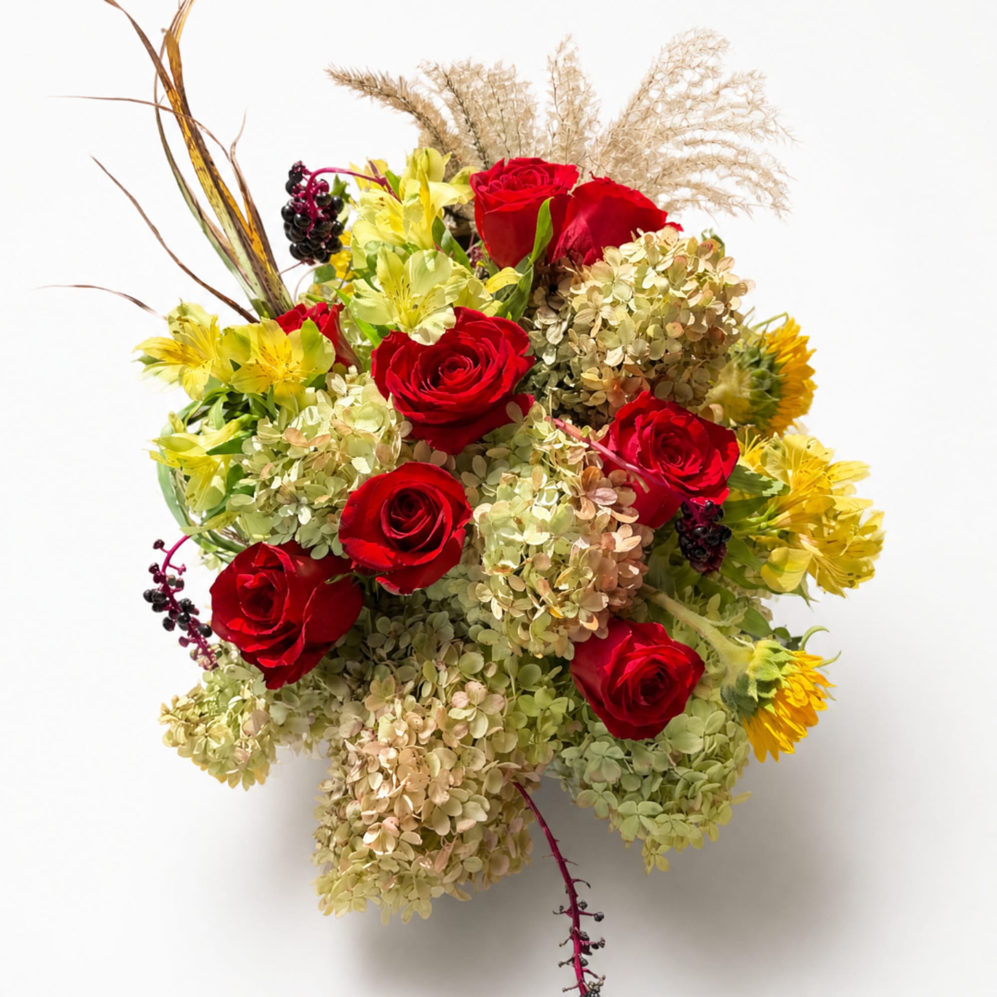 Bouquet of red roses, yellow flowers, and beige dried grasses