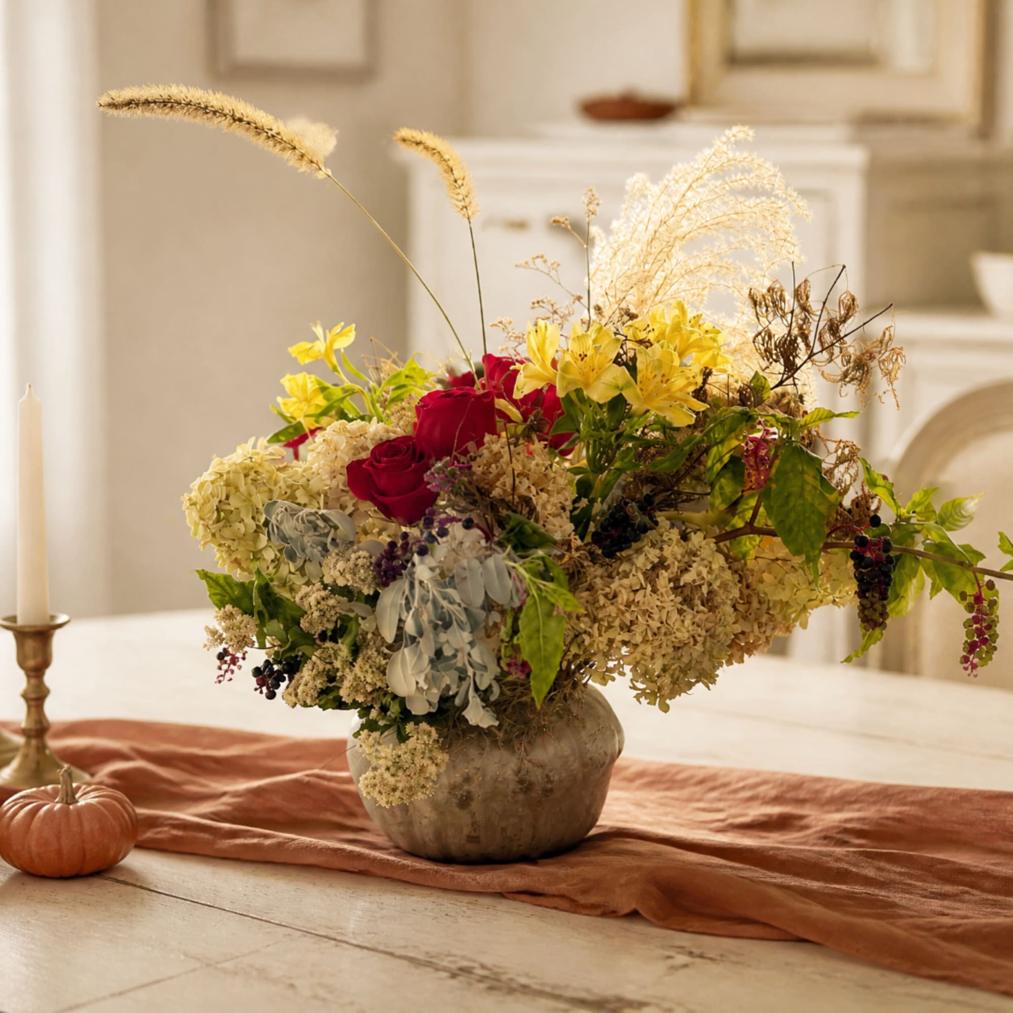 Mixed floral arrangement in a round vase with red roses and yellow lilies