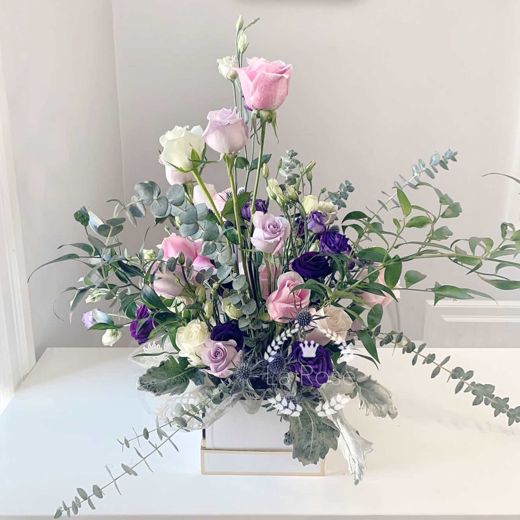 Tall pastel rose arrangement in a white box with eucalyptus