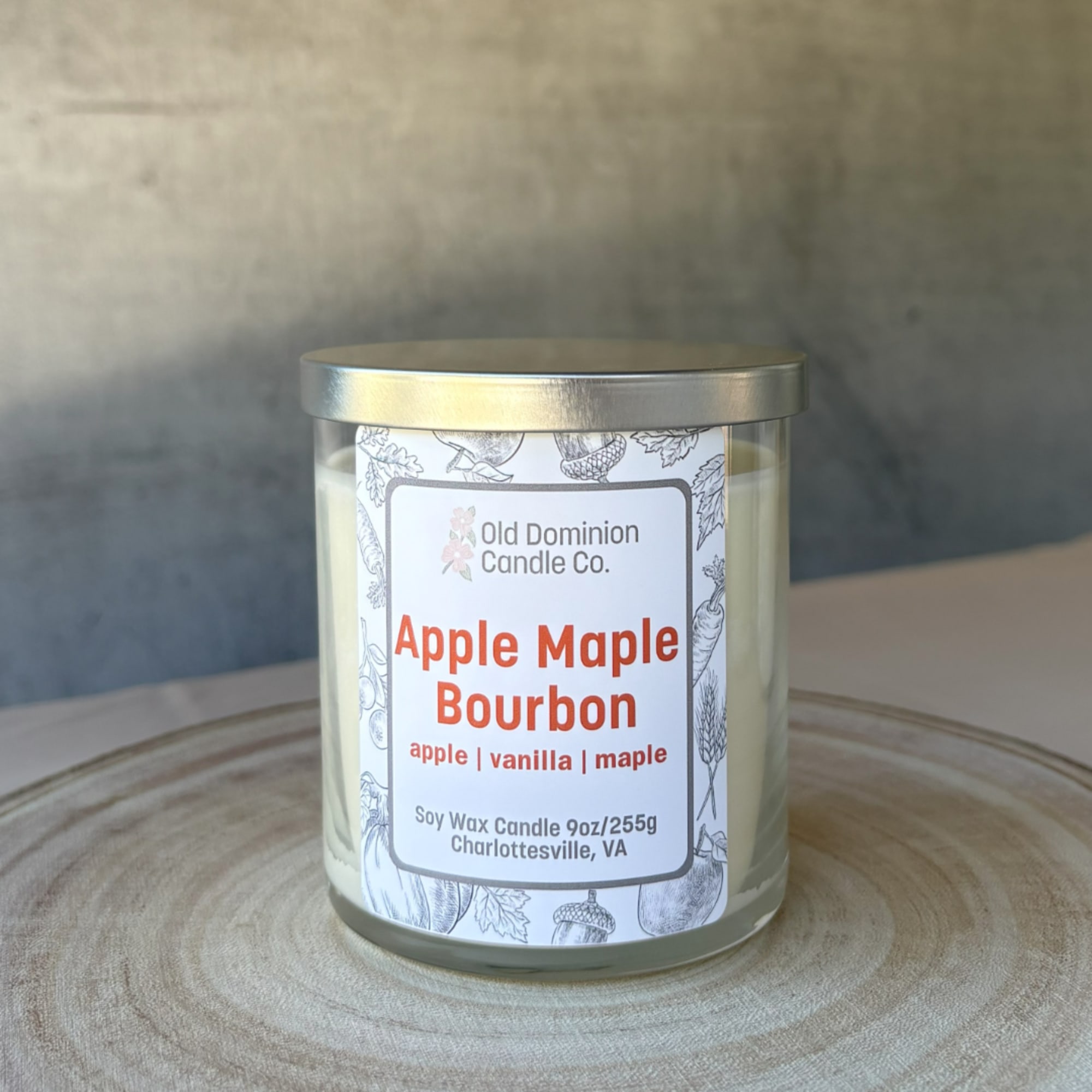 Apple Maple Bourbon soy candle in a glass jar with a metal lid
