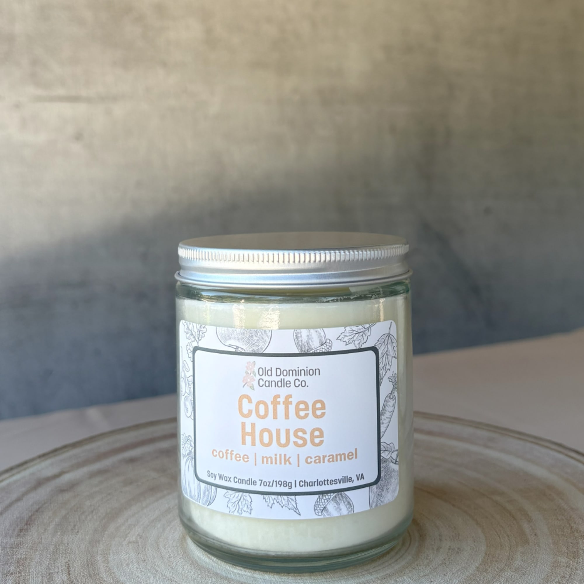 Jar candle labeled Coffee House on a wooden surface