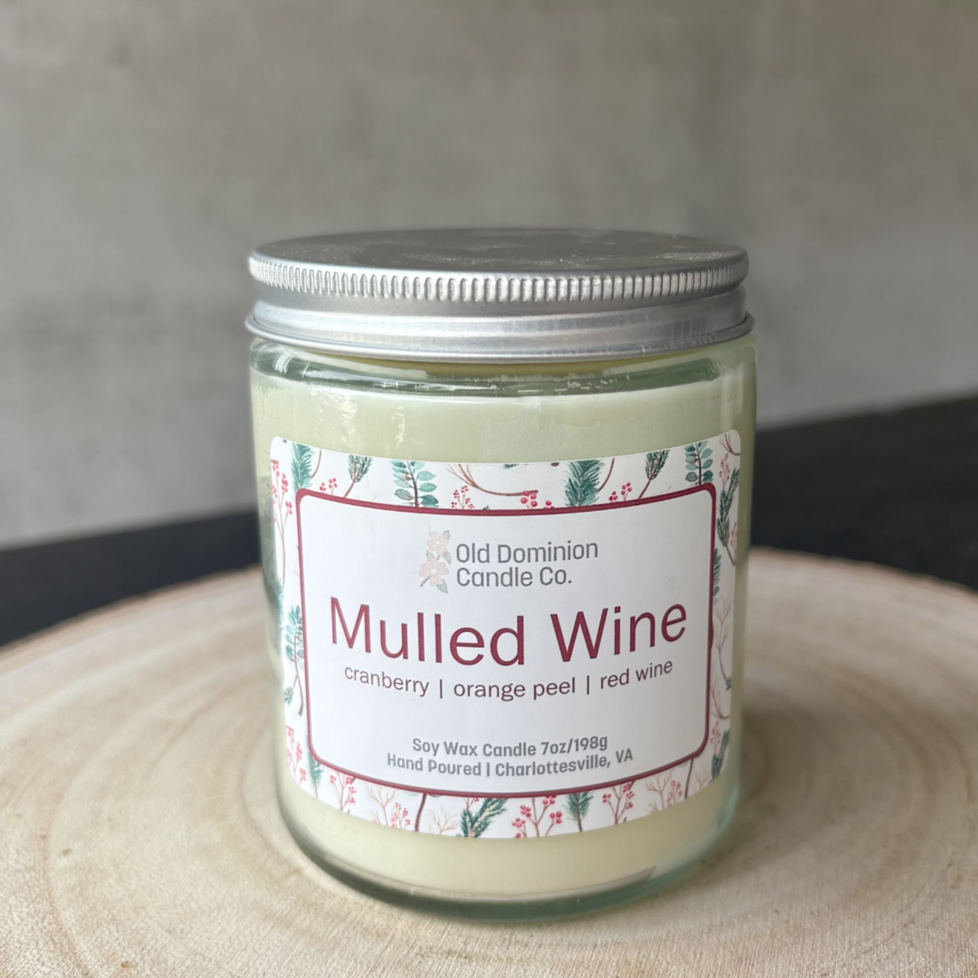 Jar candle labeled Mulled Wine on a wooden surface