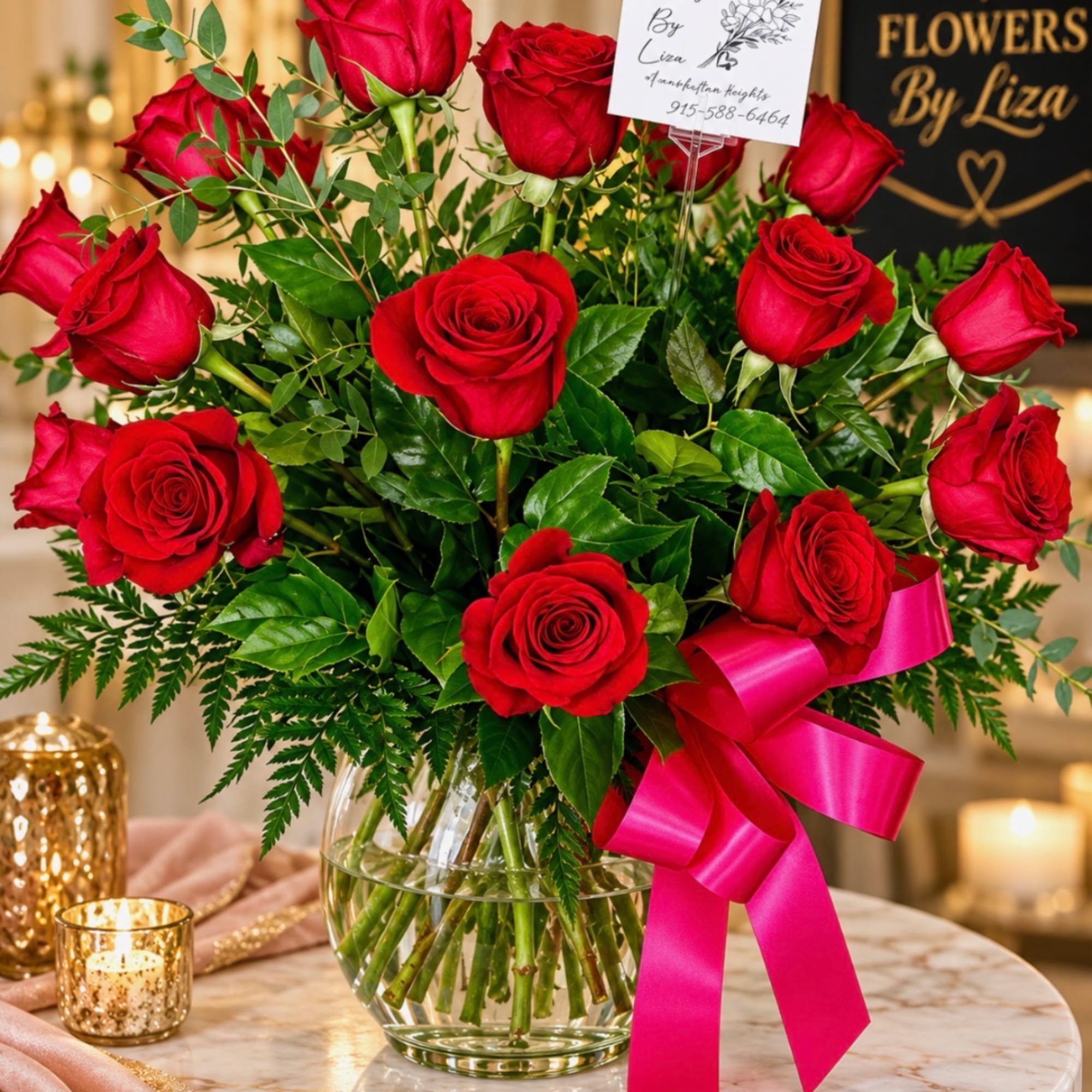 Red roses in a glass vase with a pink ribbon