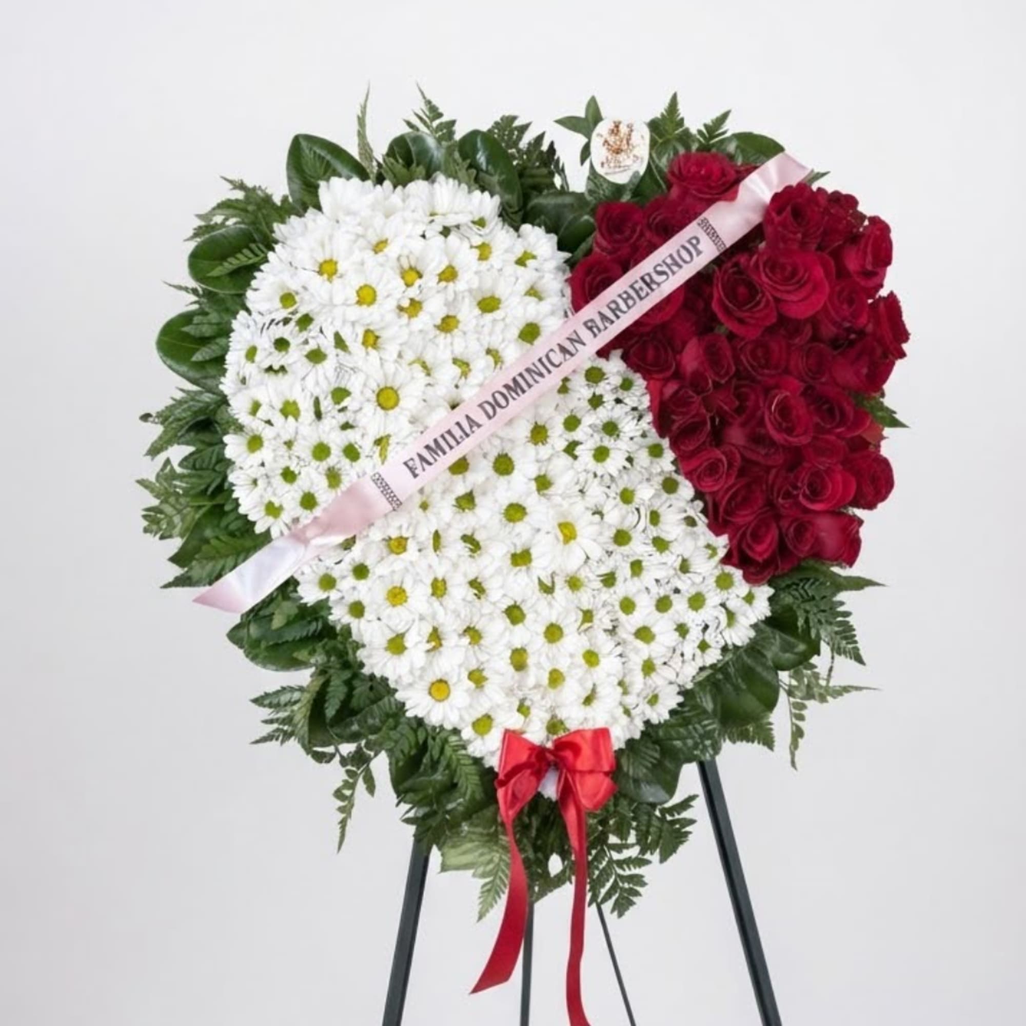 Heart-shaped floral standing spray with white daisies and red roses on an easel