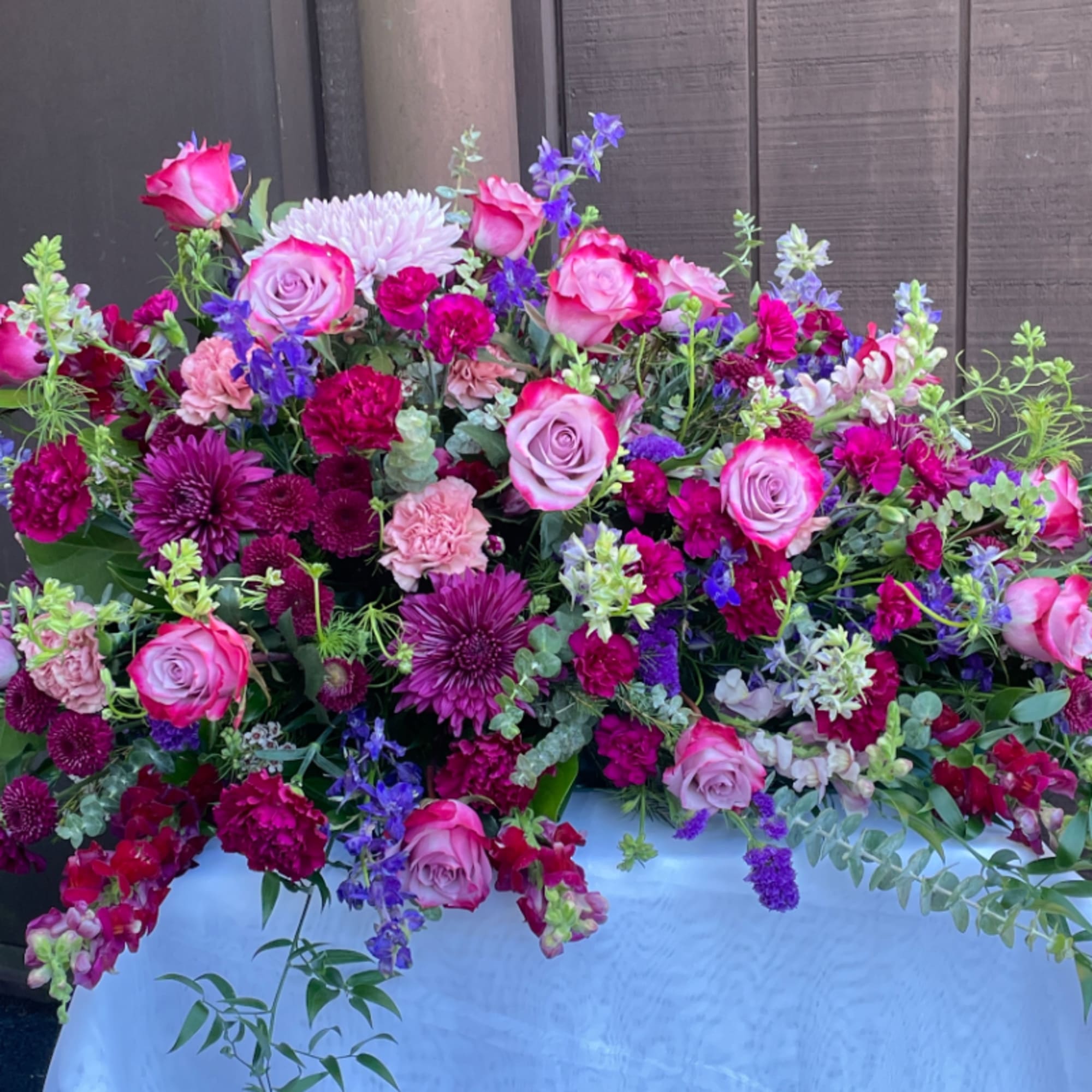 Large bouquet of pink and purple flowers arranged in a white container