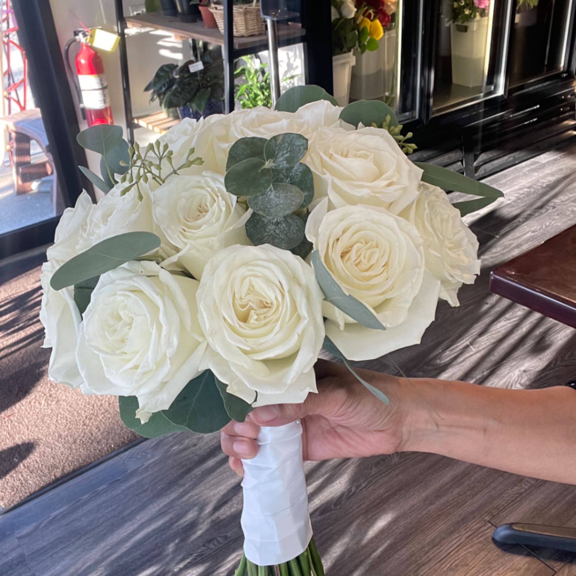 White rose bridal bouquet with eucalyptus greenery, photo 2 of 3