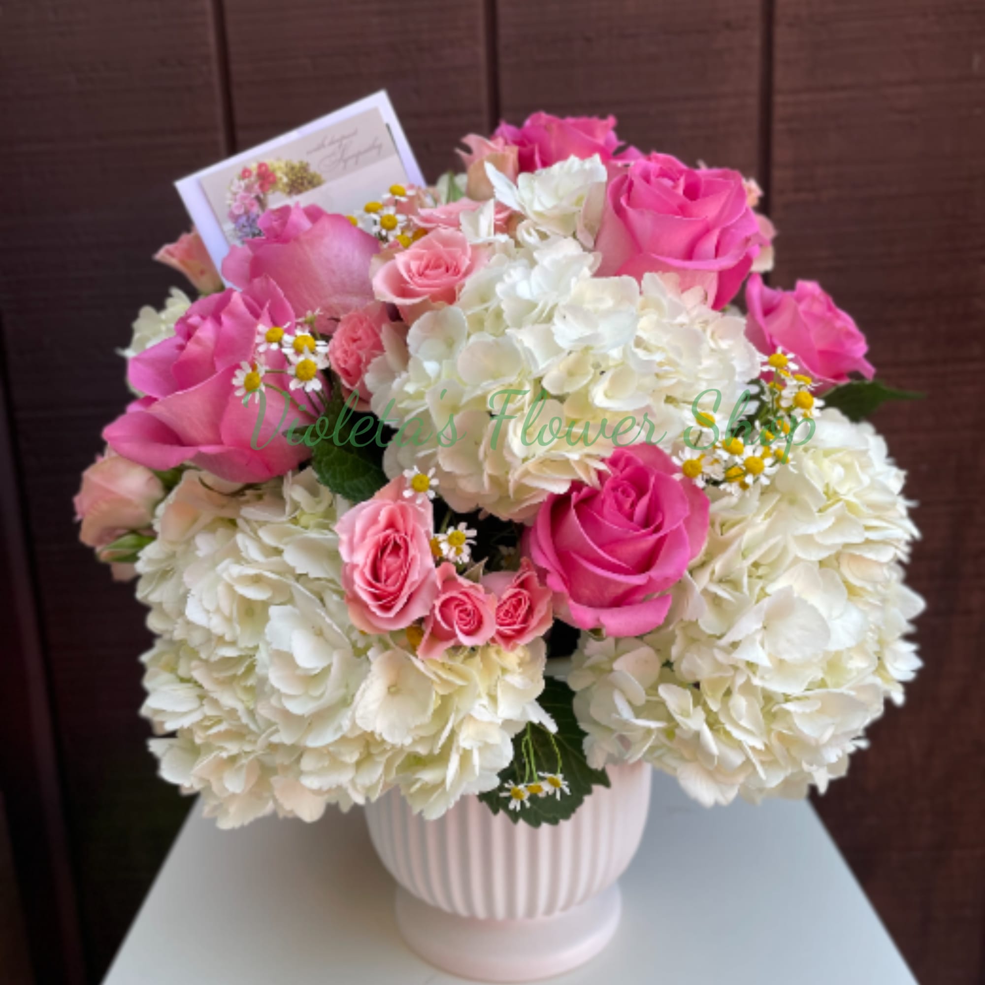 Bright pink and blush roses rise above billowy white hydrangea clusters in