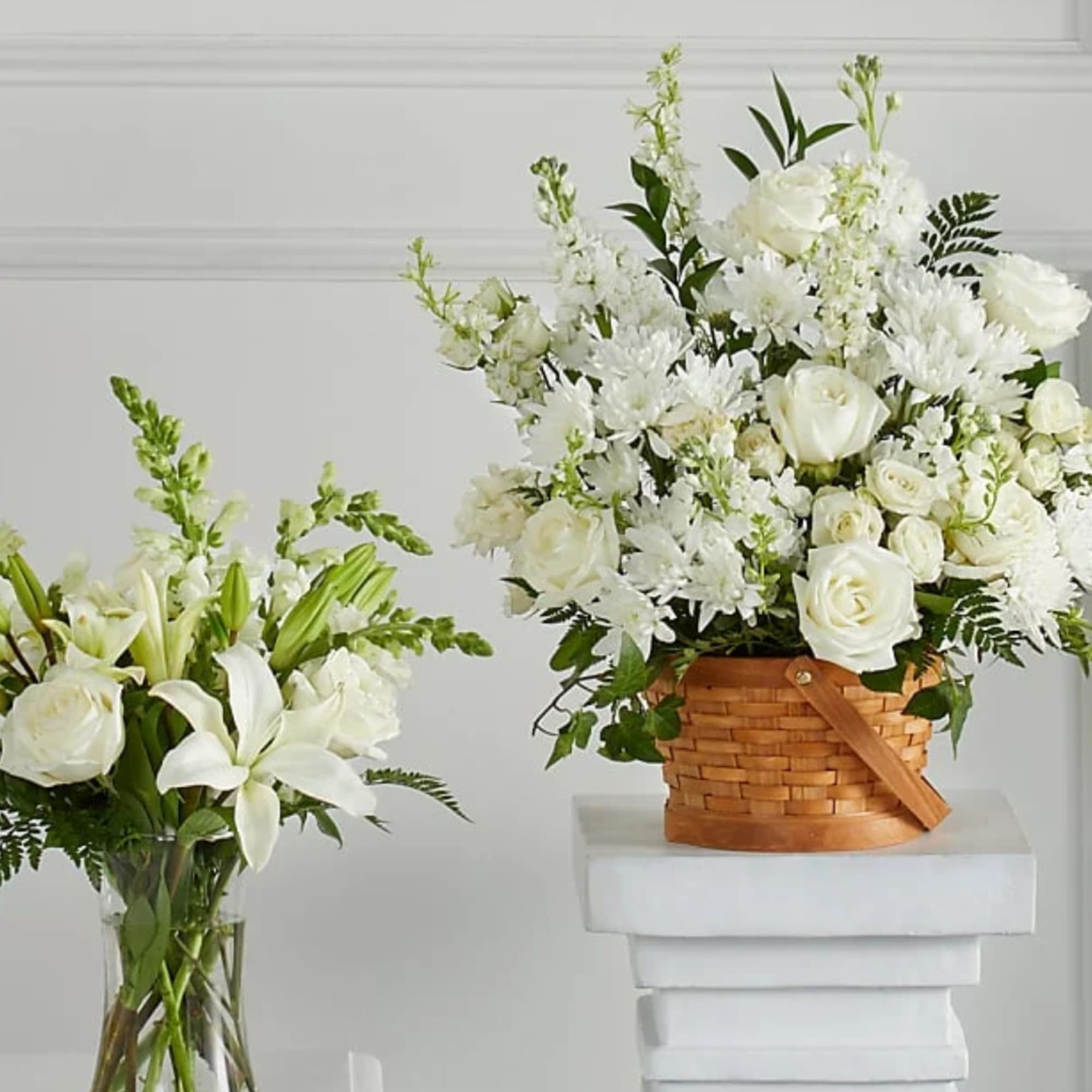 White floral arrangements in a glass vase and wicker basket