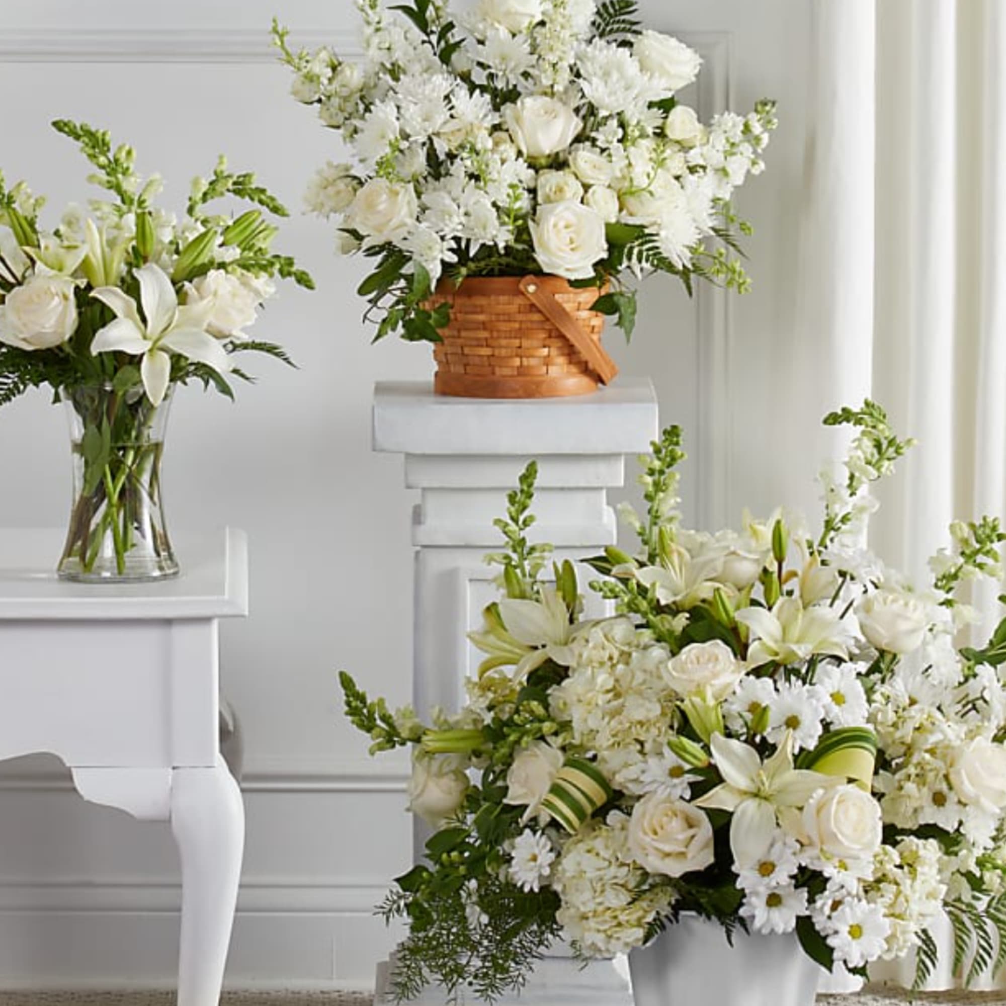 White floral arrangements in baskets, glass, and ceramic containers