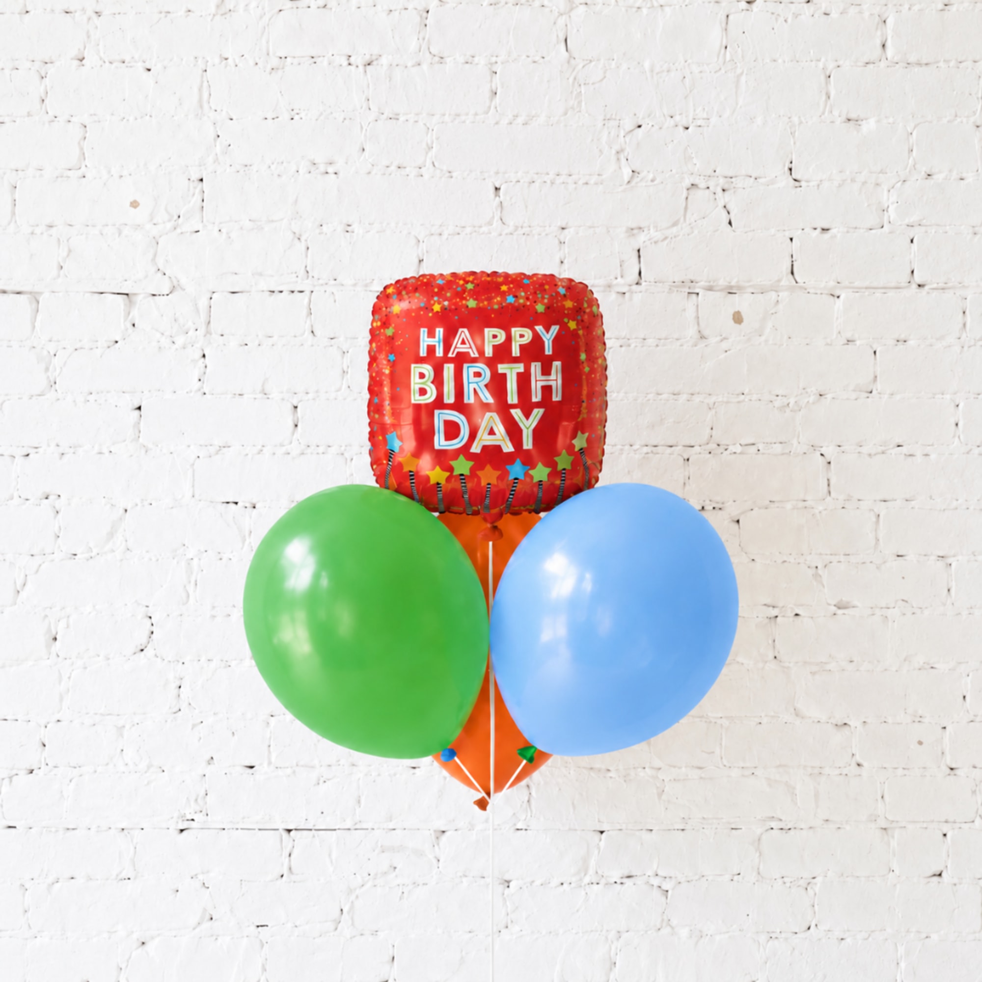 Birthday balloon bouquet with a red happy birthday foil balloon and two latex balloons