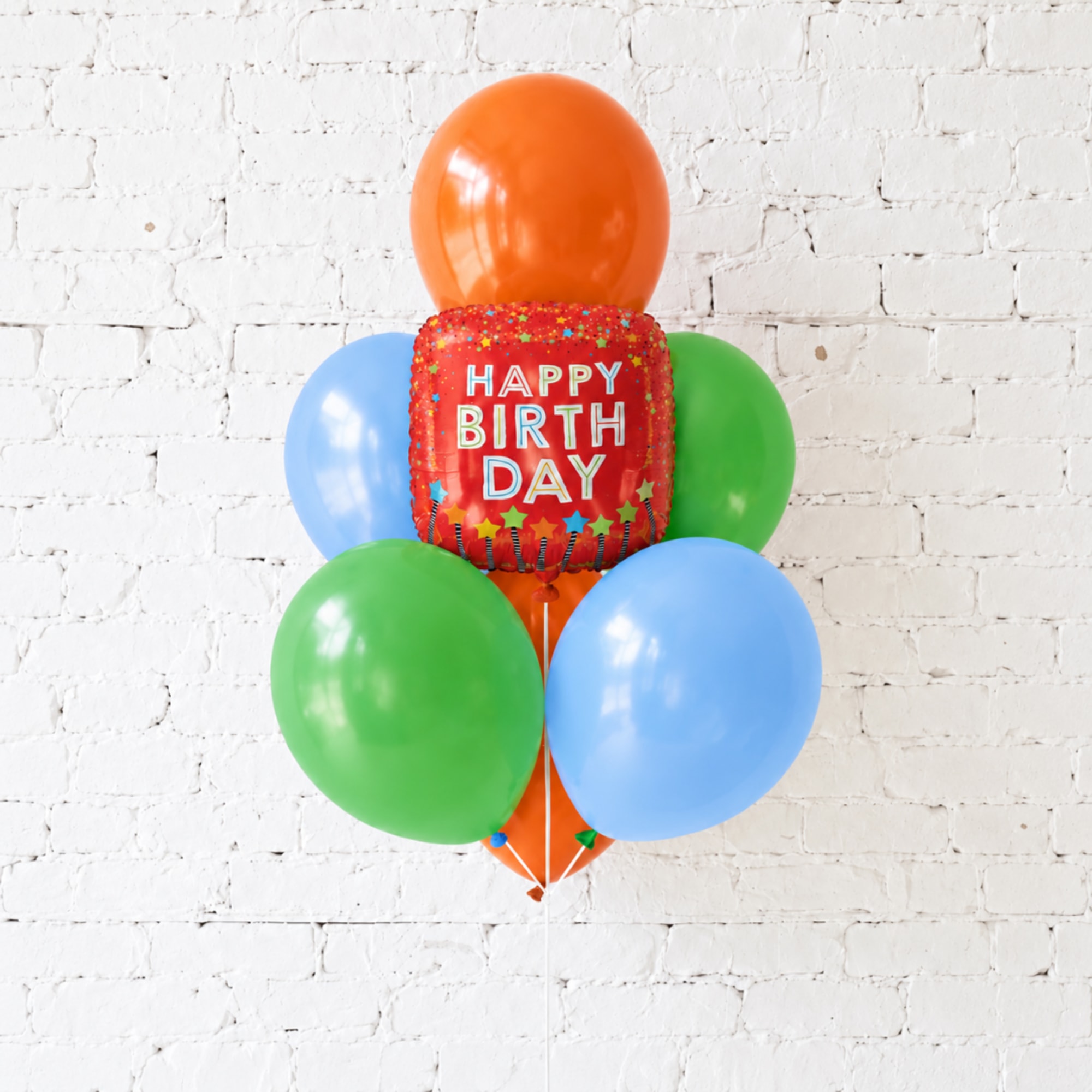Birthday balloon cluster with a red "Happy Birthday" balloon and colorful round balloons